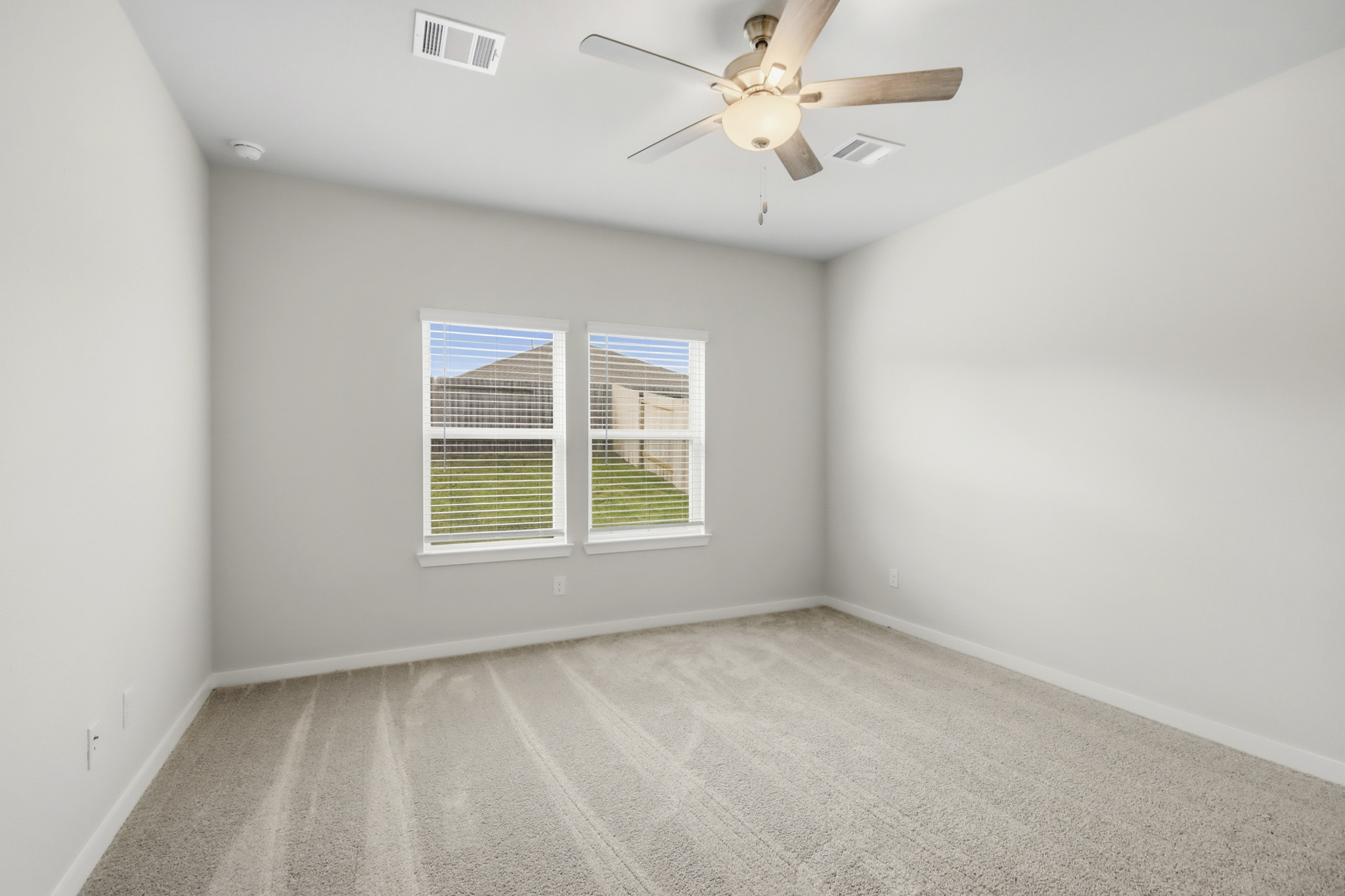 A room with a ceiling fan and a window.