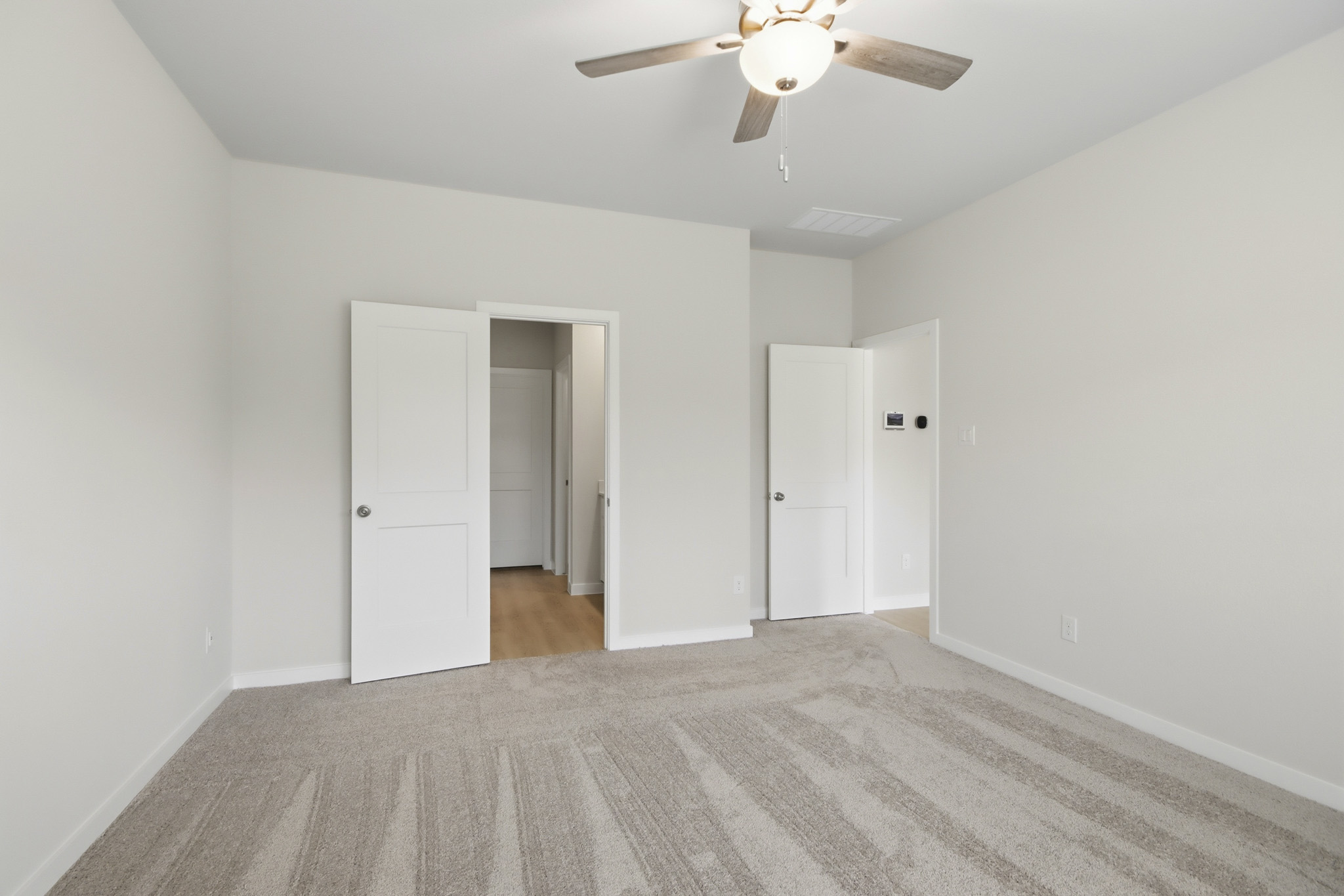 A room with white walls and a ceiling fan.