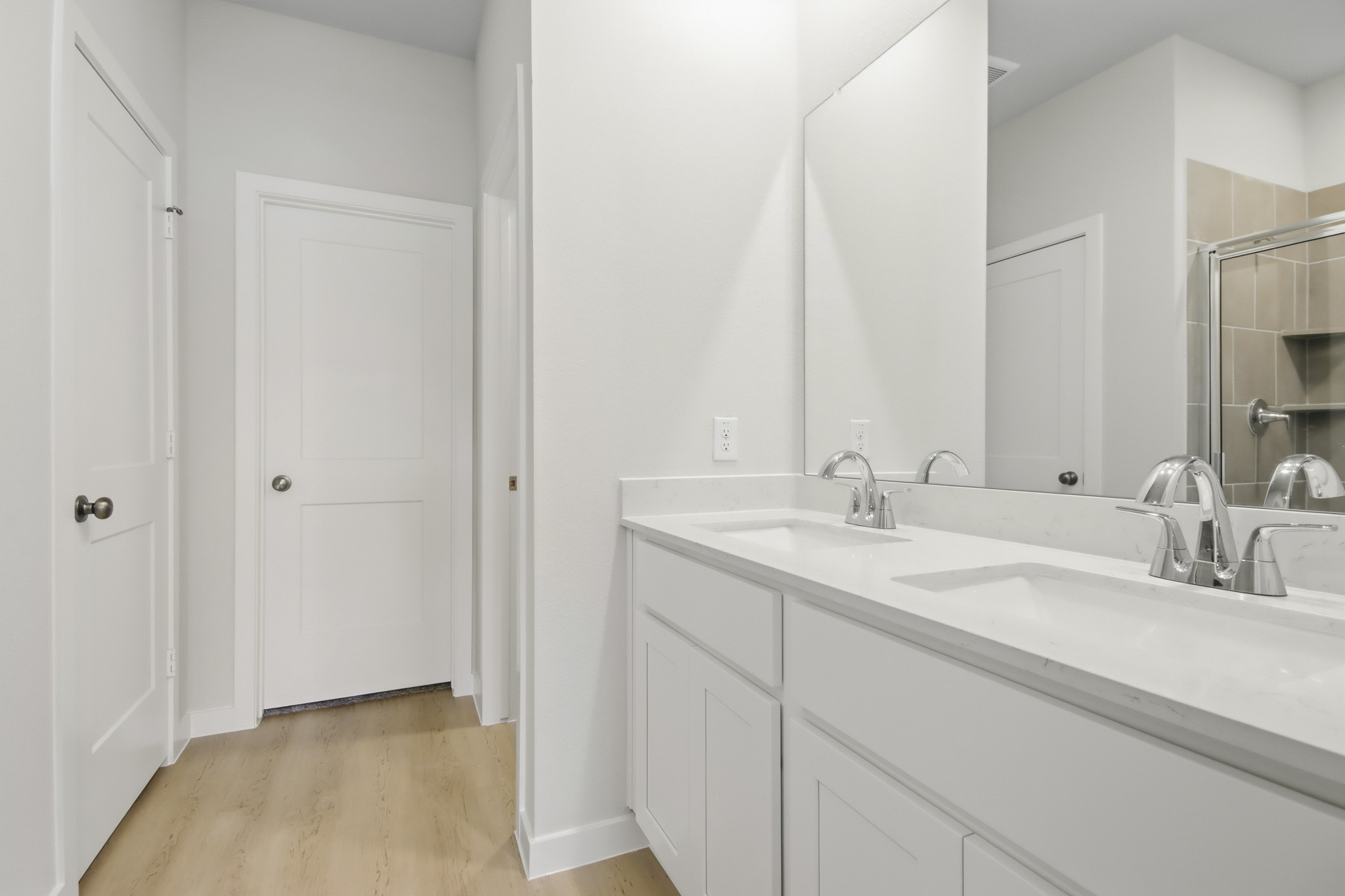 A bathroom with white cabinets.
