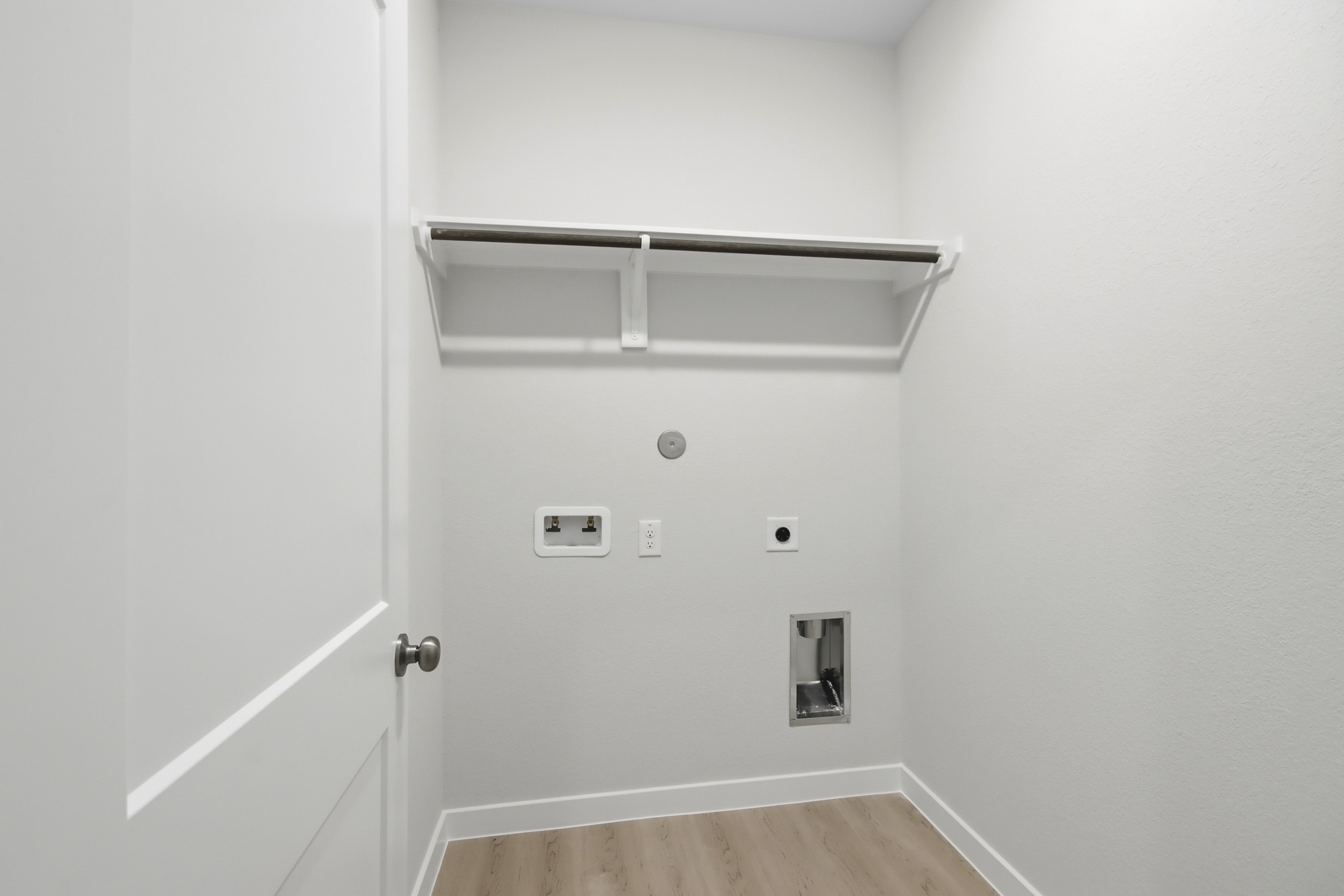 A white wall with a metal shelf.