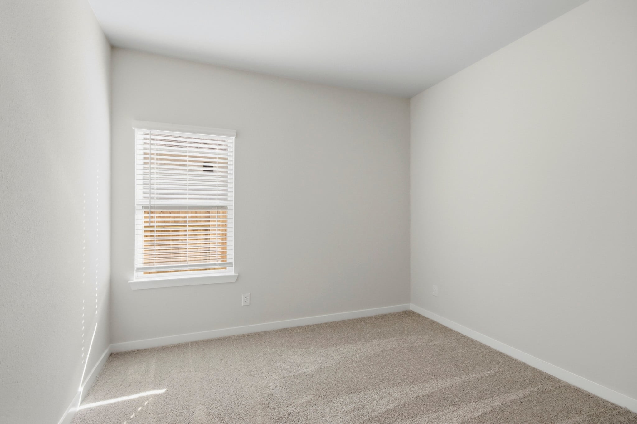 A room with a window and a carpet.