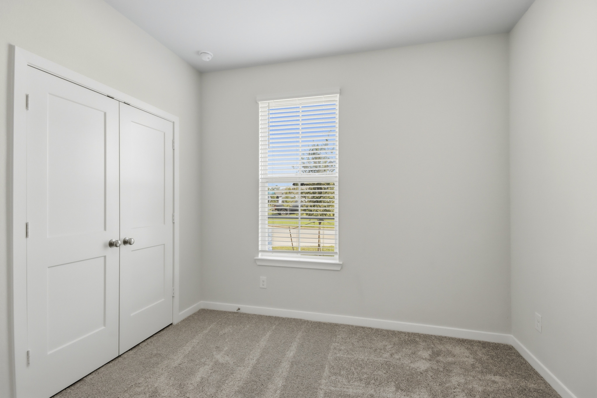 A room with white doors and a window.