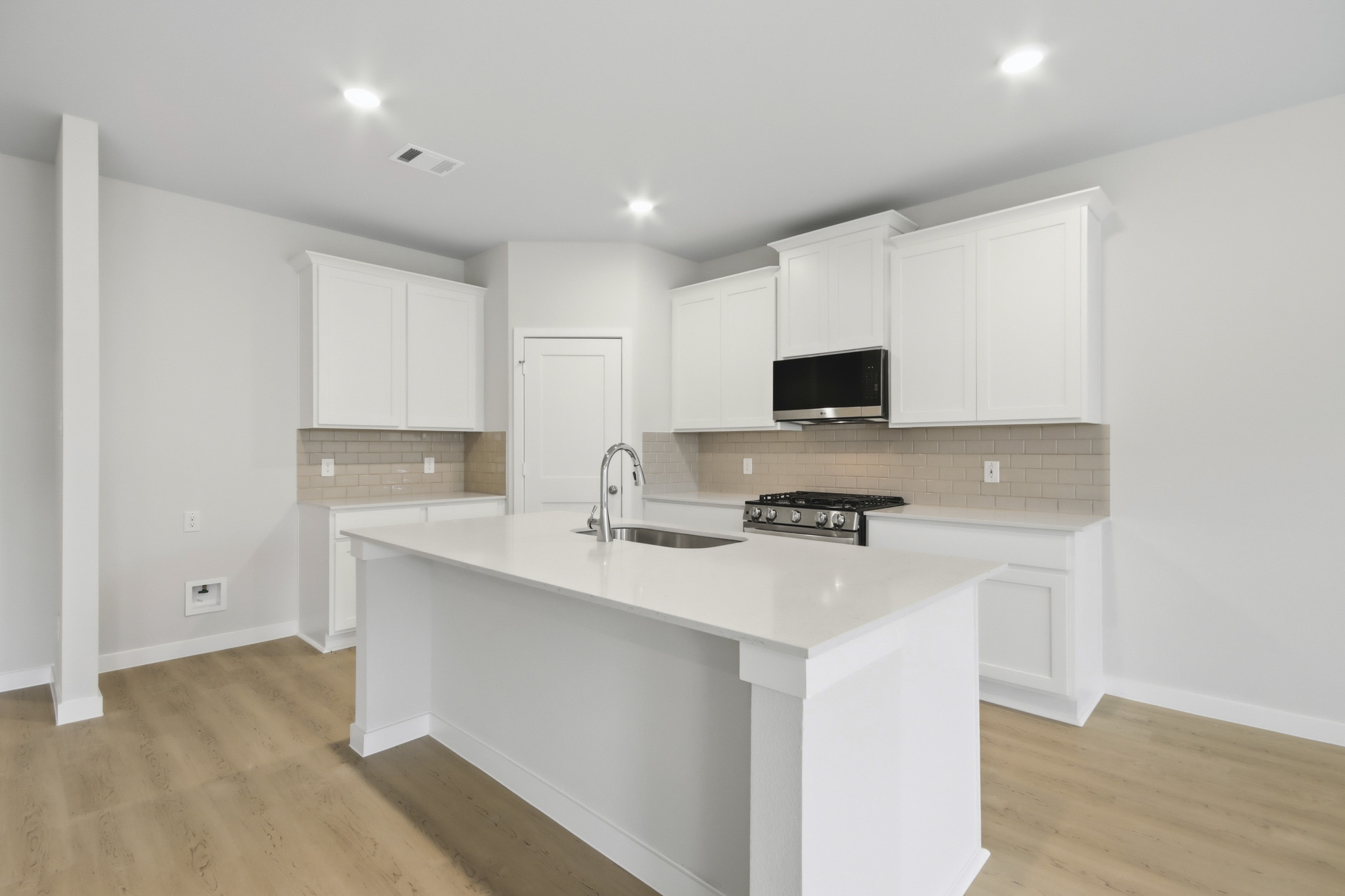 A kitchen with white cabinets.