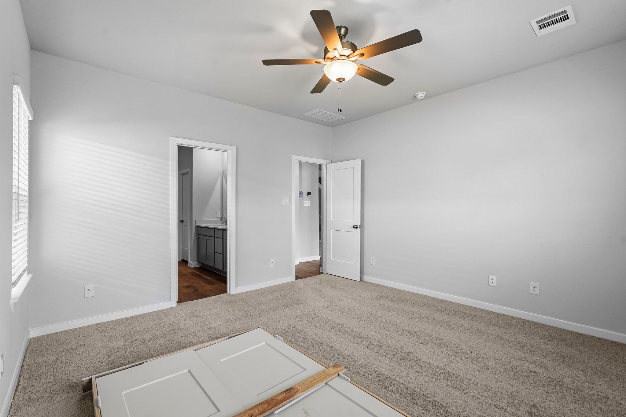 A room with a ceiling fan and a tile floor.