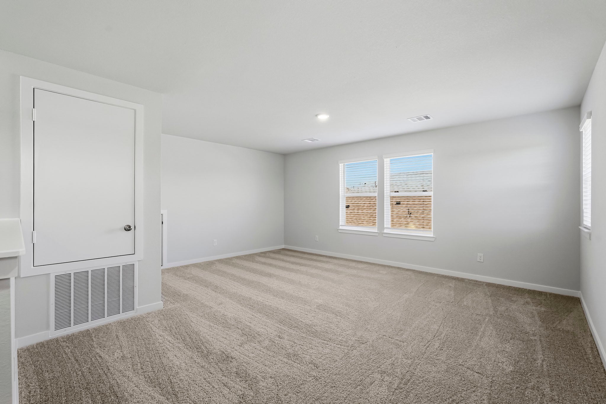 A room with a white wall and a window.