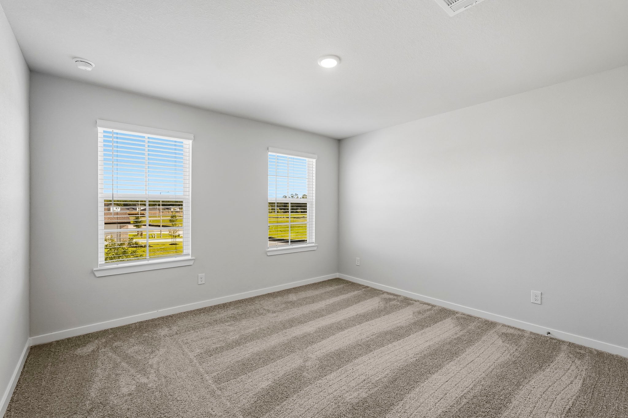 A room with windows and a carpet.