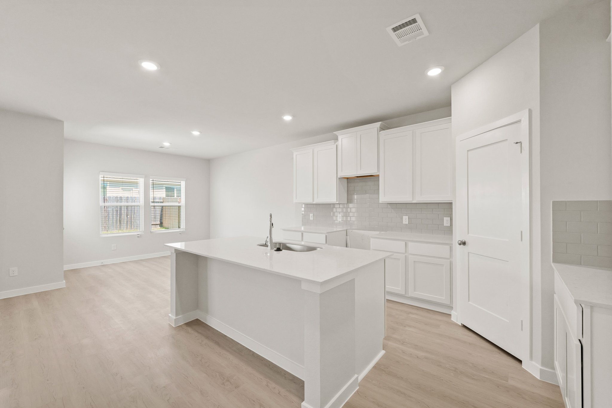 A kitchen with white cabinets.