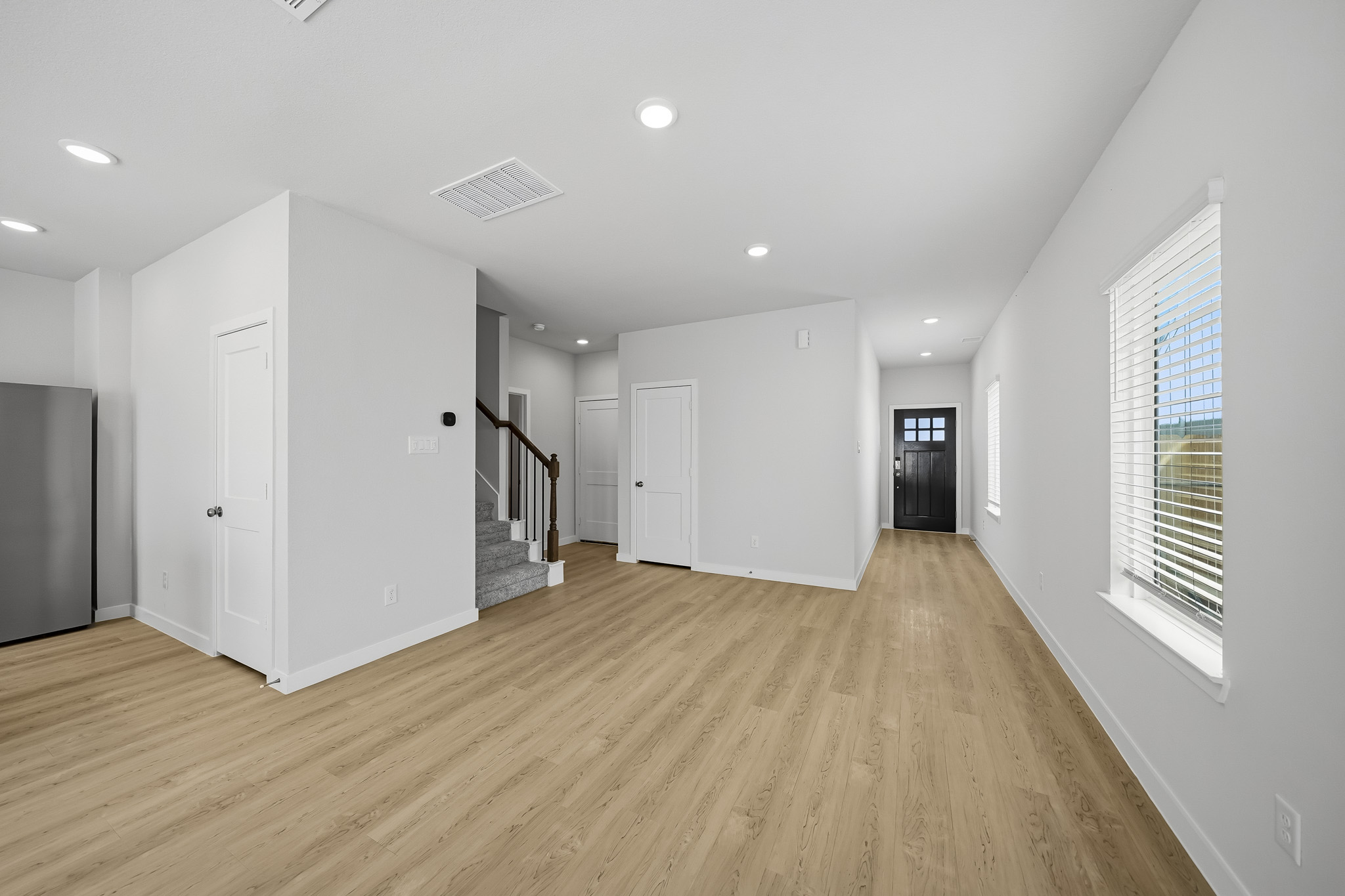 A room with white walls and wood floors.