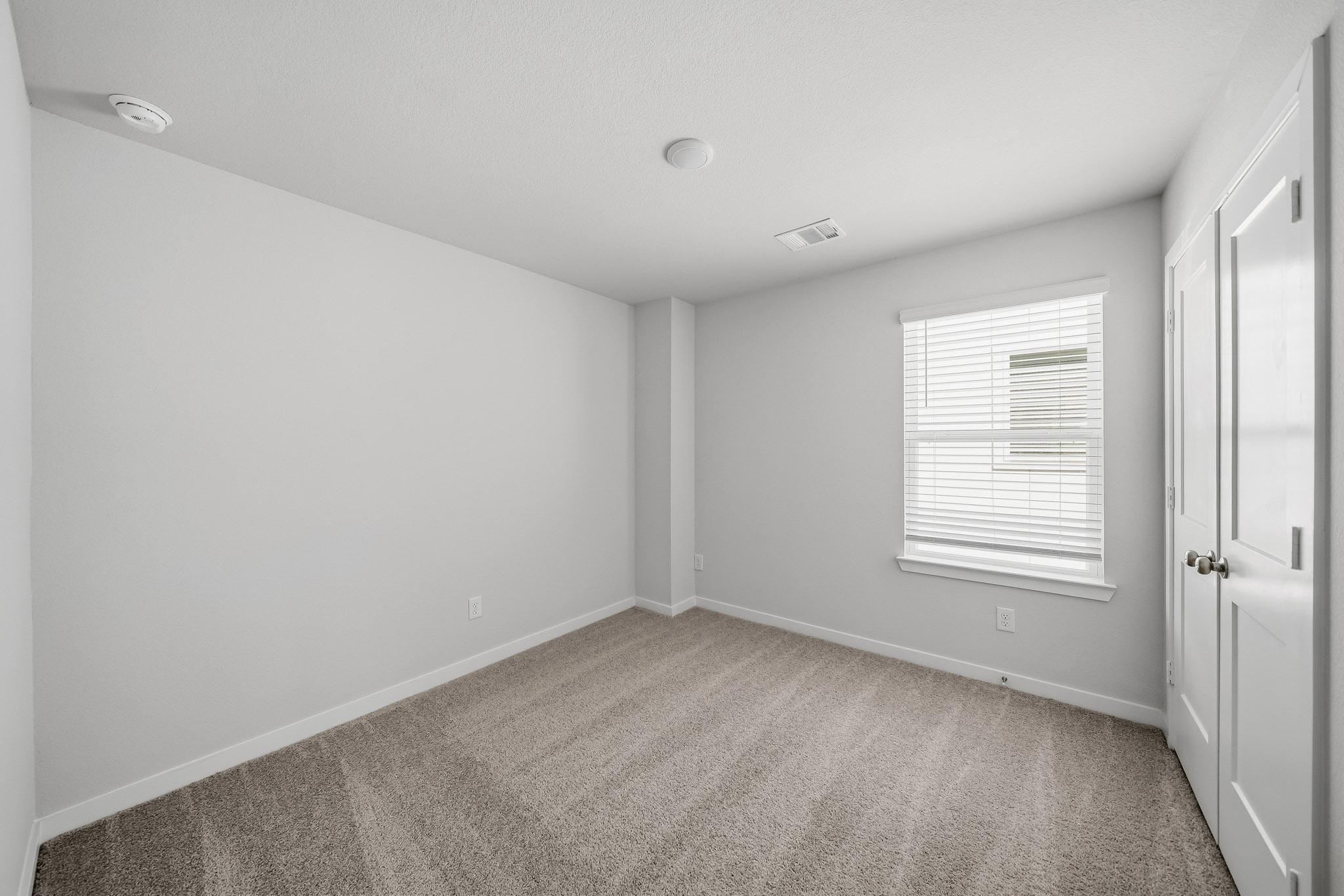 A room with white walls and a carpet.