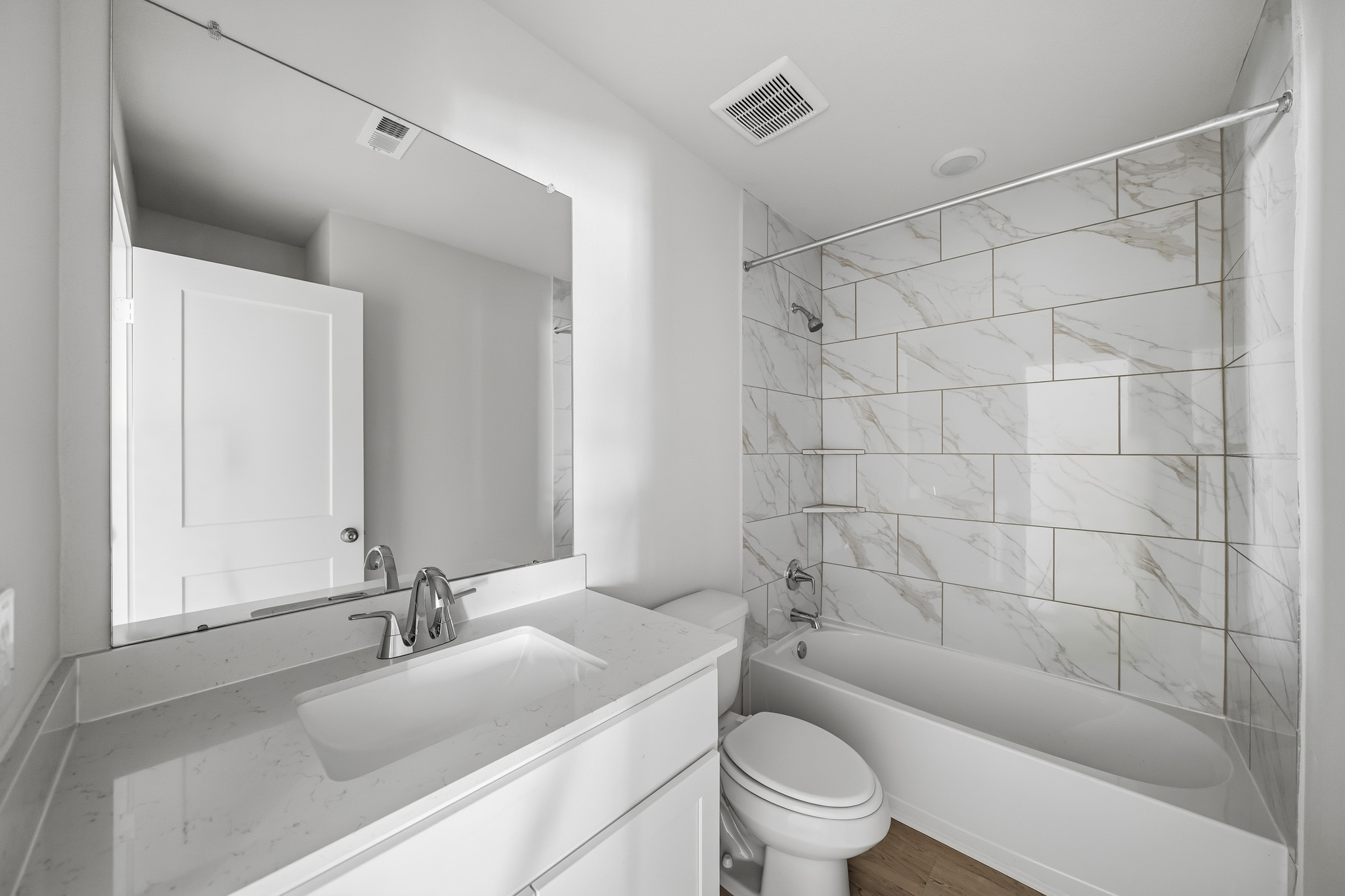 A bathroom with a tub sink and toilet.