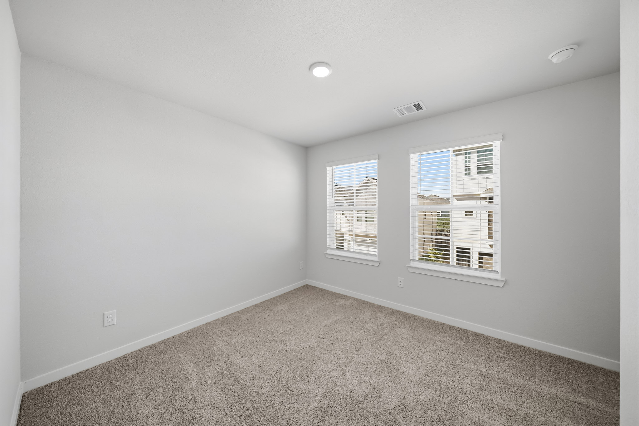 A room with a window and a carpet.