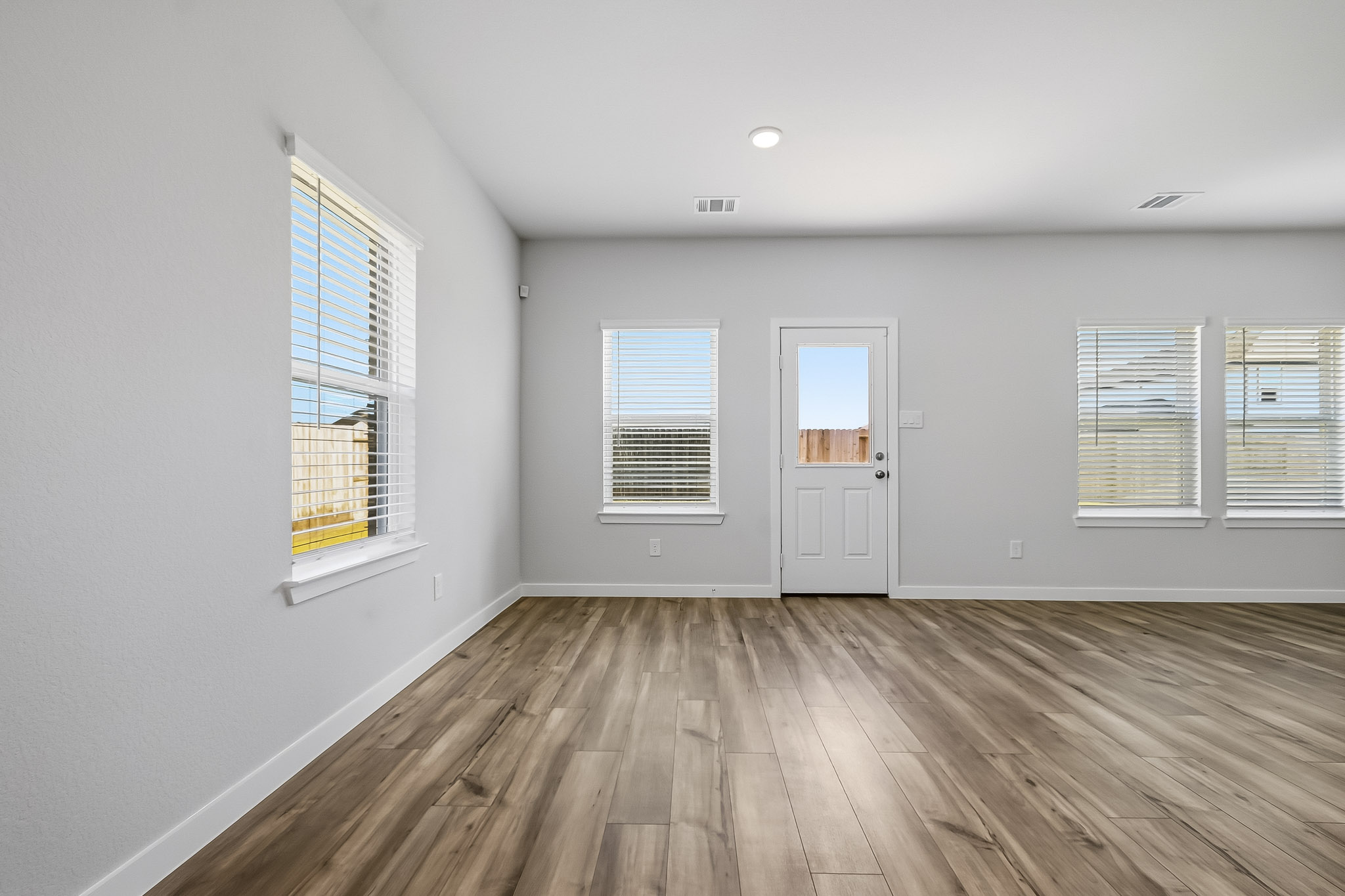 A room with a wood floor and windows.