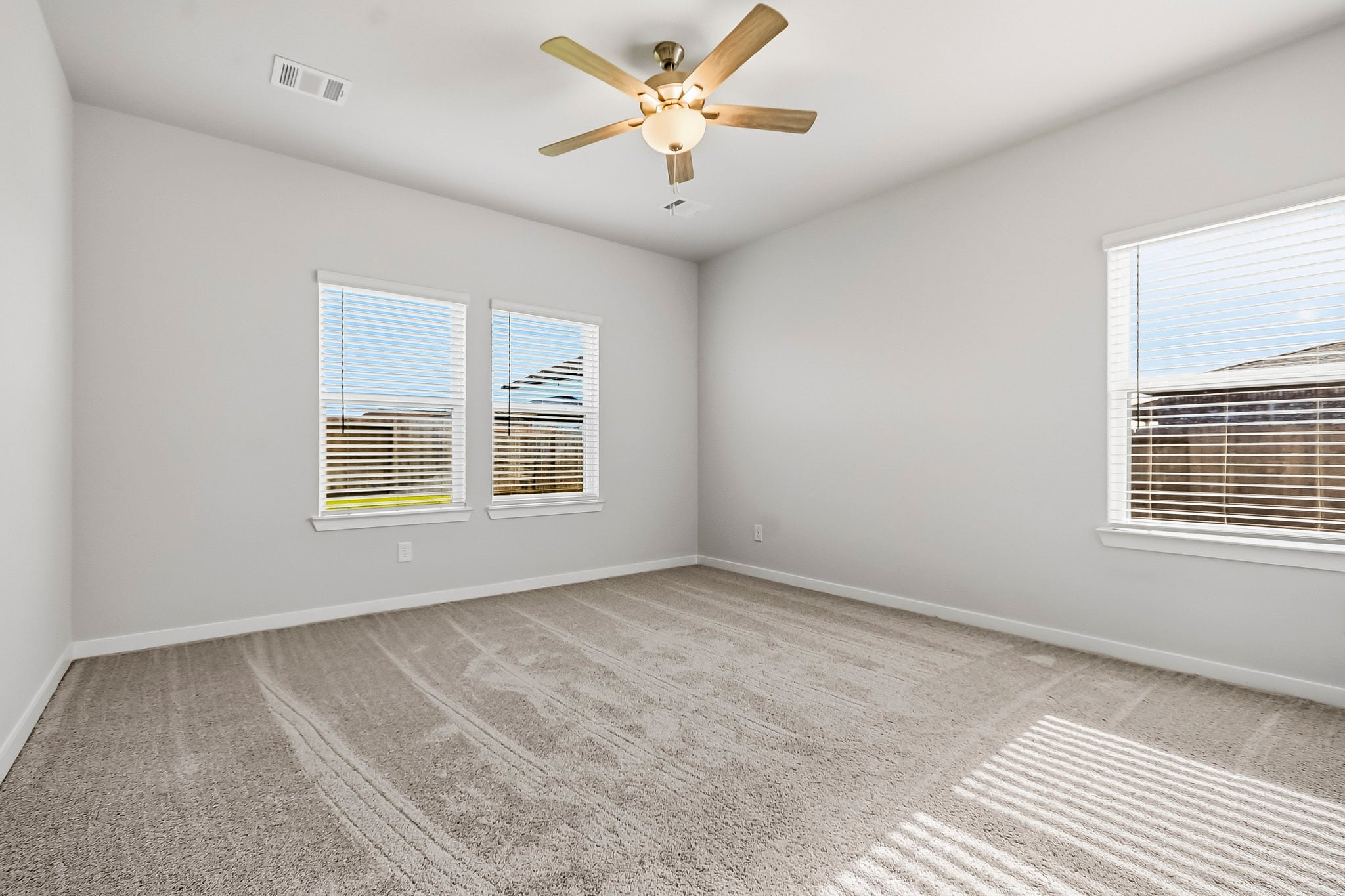 A room with a ceiling fan and a window.