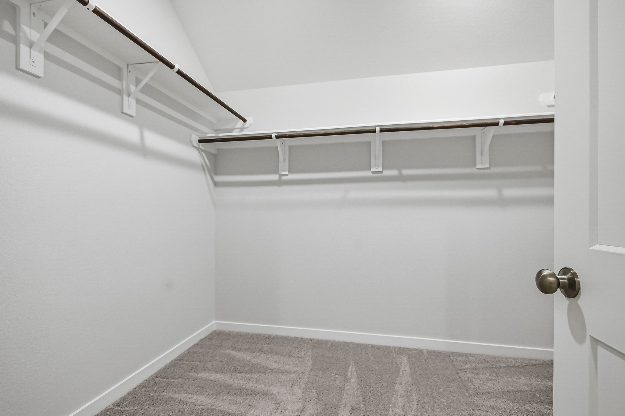 A white room with a white wall and a metal railing.