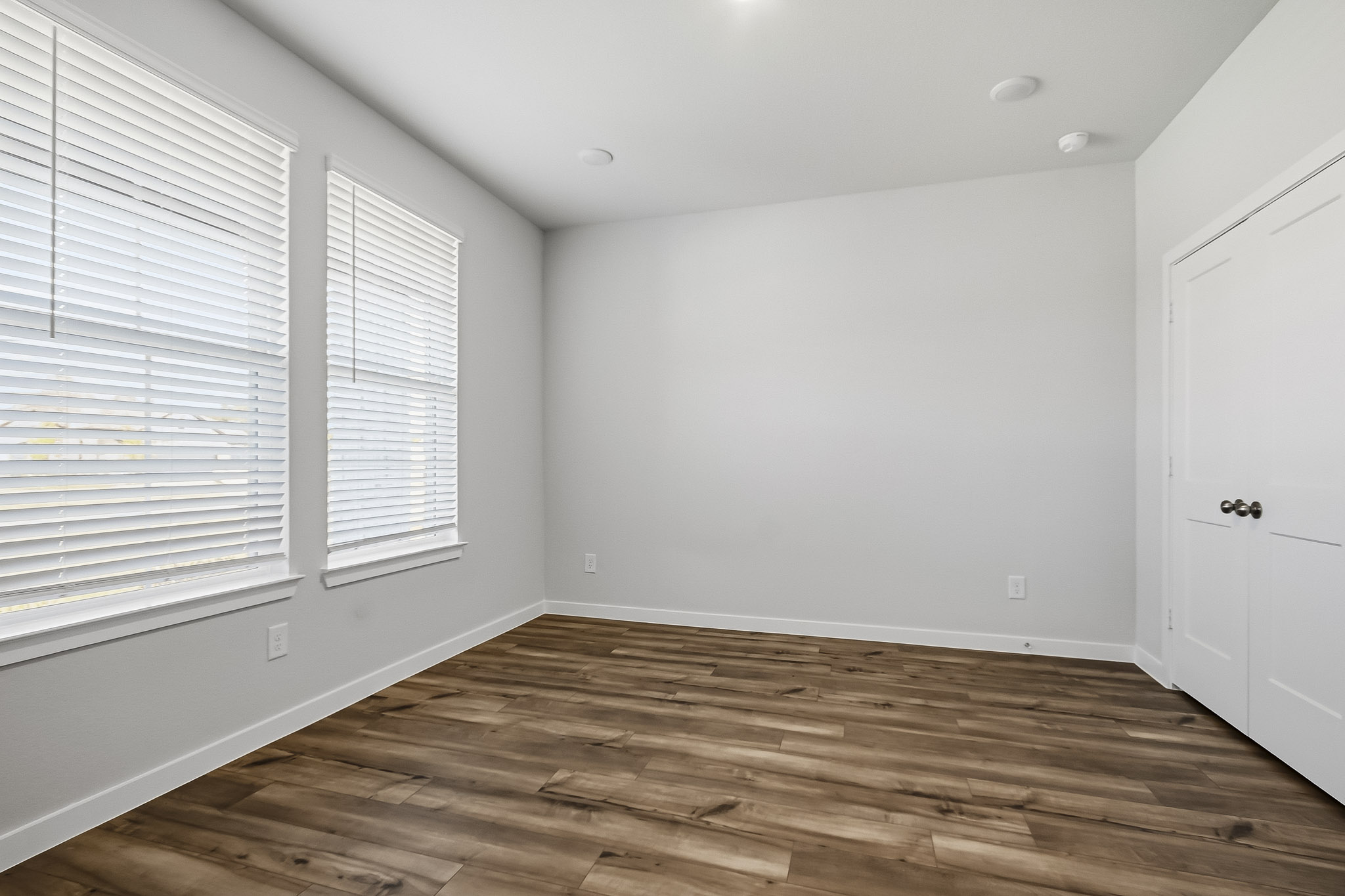 A room with a wood floor and white walls.
