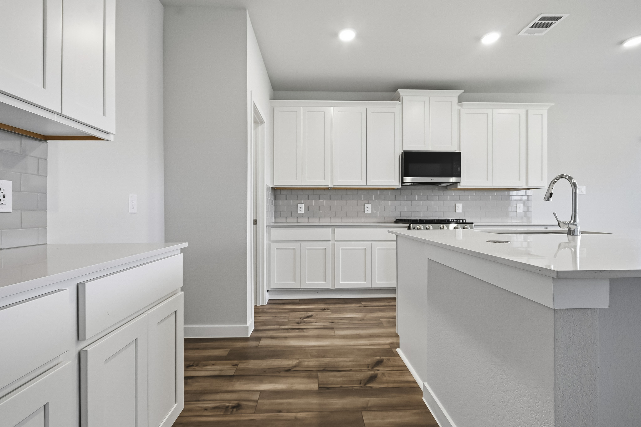 A kitchen with white cabinets.