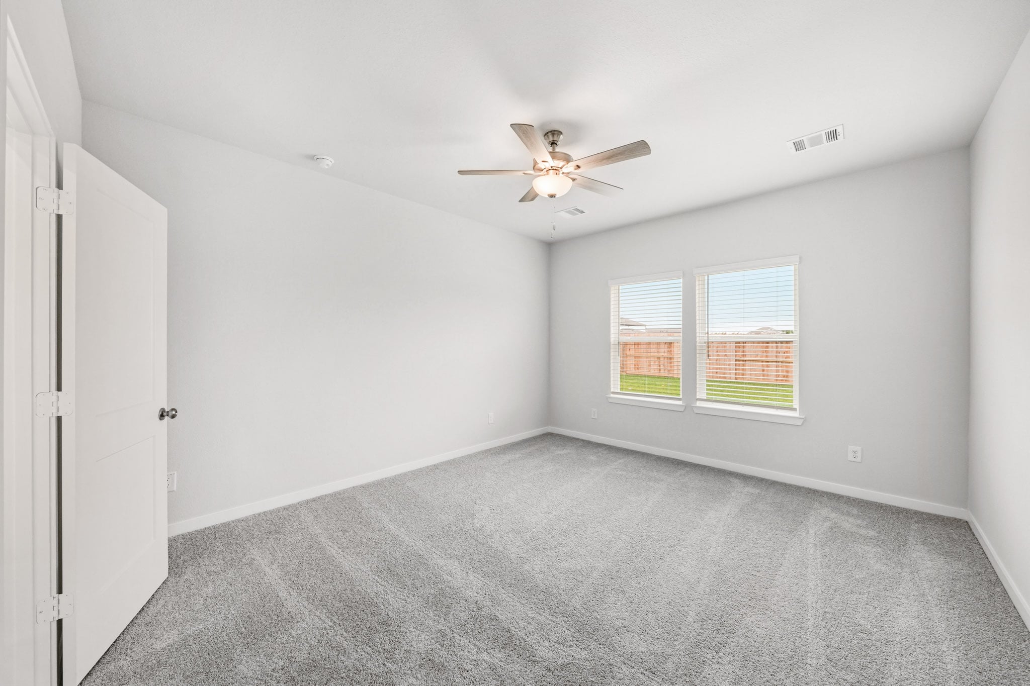 A room with a ceiling fan and a window.