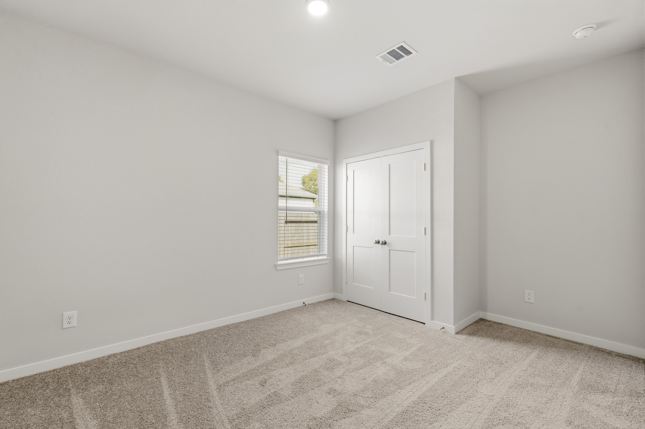 A room with white walls and a window.