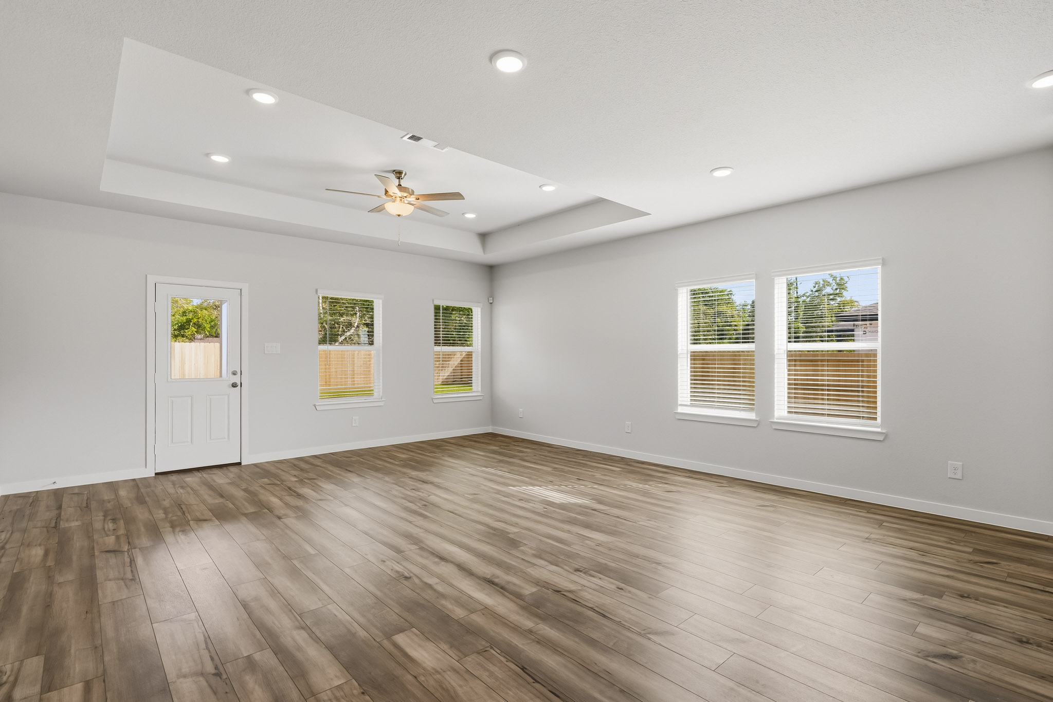 A room with a wood floor and a ceiling fan.