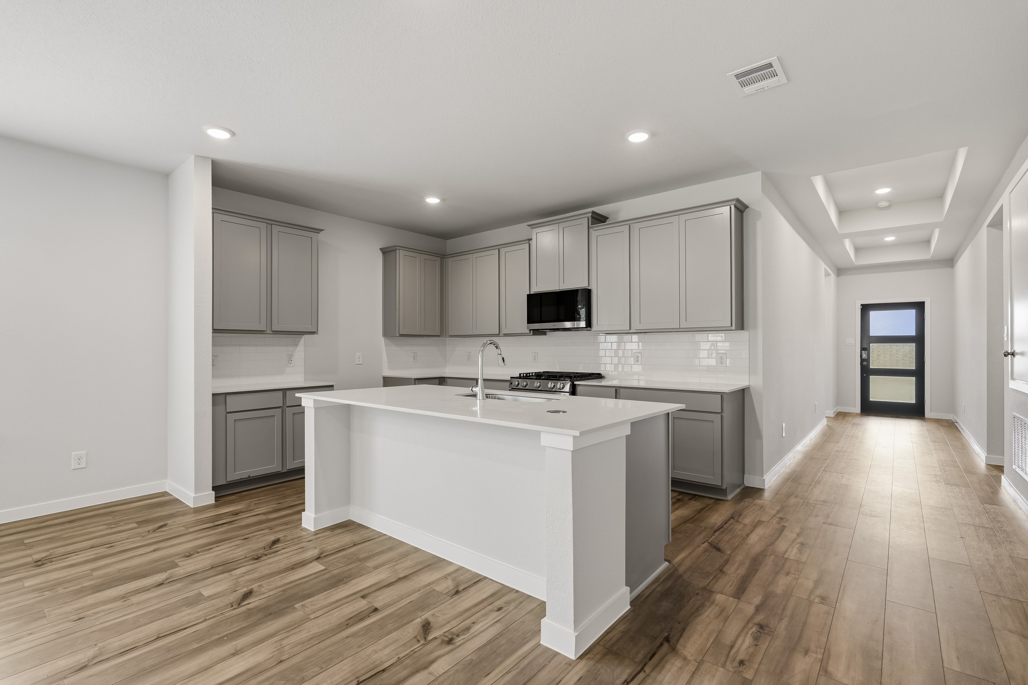 A kitchen with white cabinets.