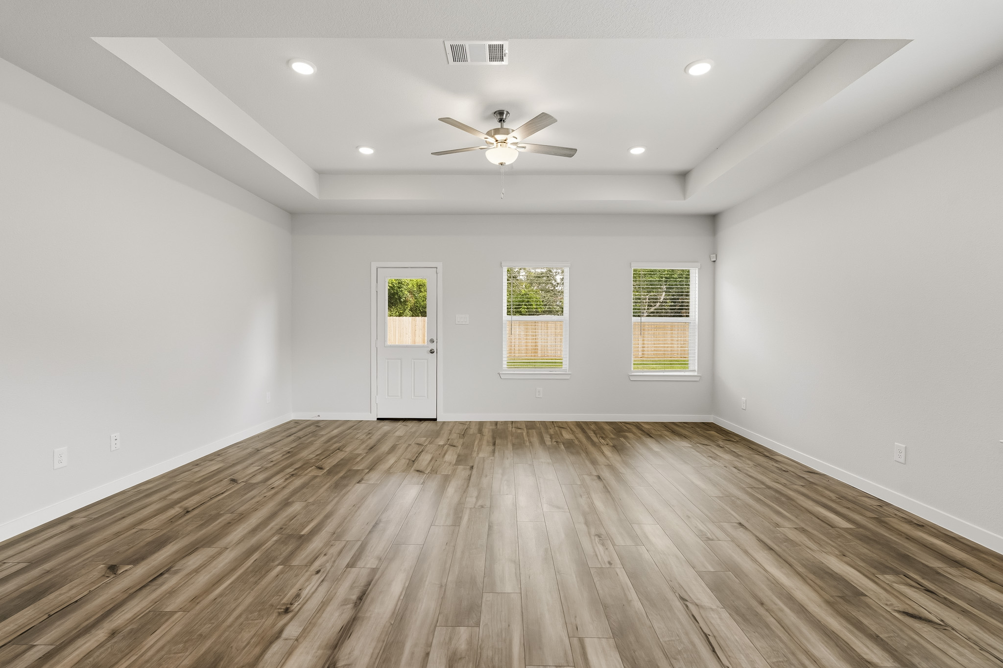 A room with a wood floor and a ceiling fan.