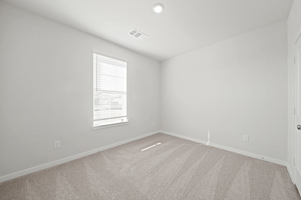 A room with a window and a carpet.