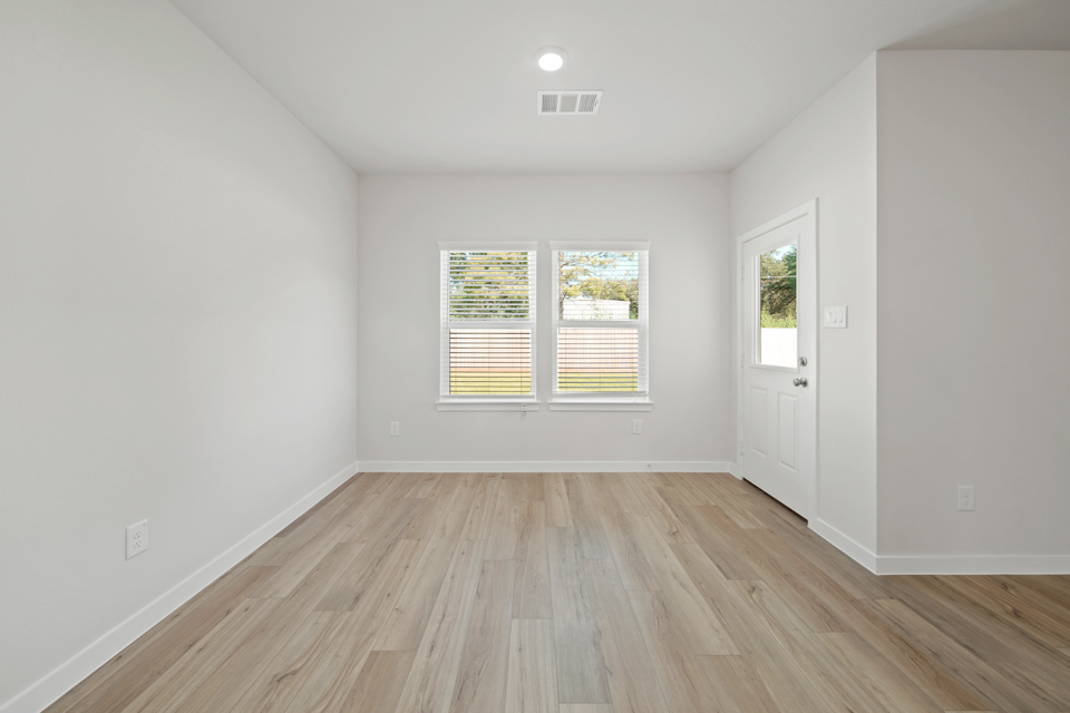 A room with a wood floor and windows.