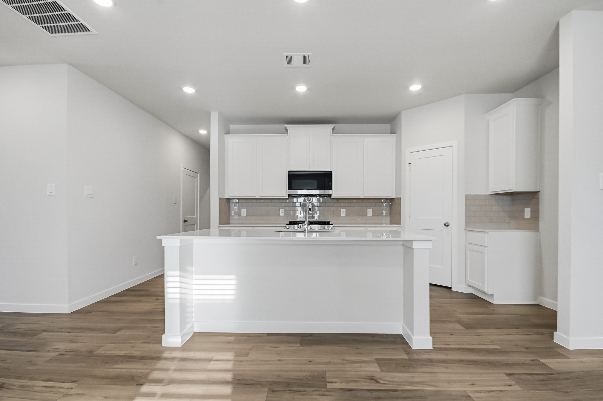 A kitchen with white cabinets.