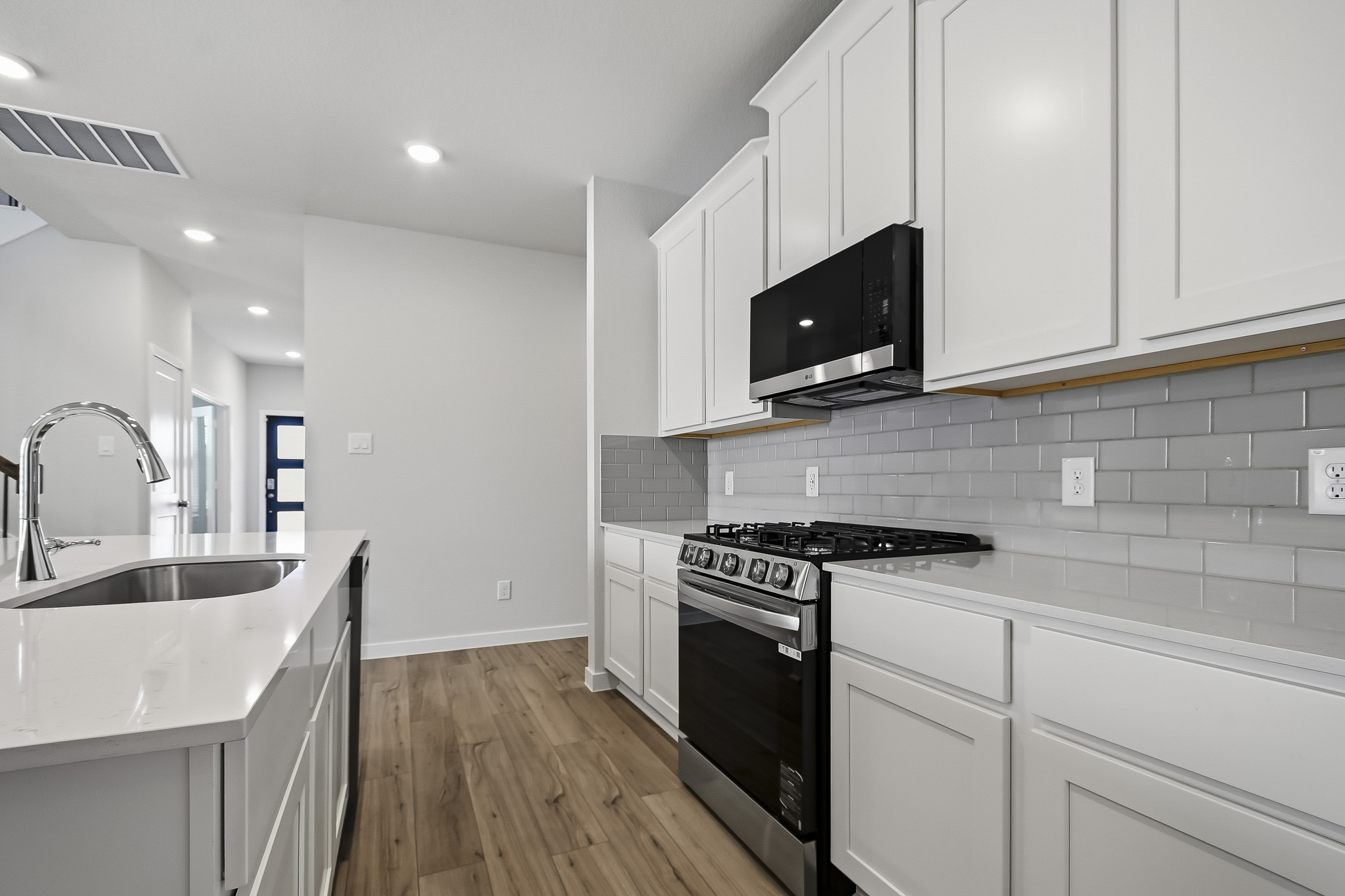 A kitchen with white cabinets.