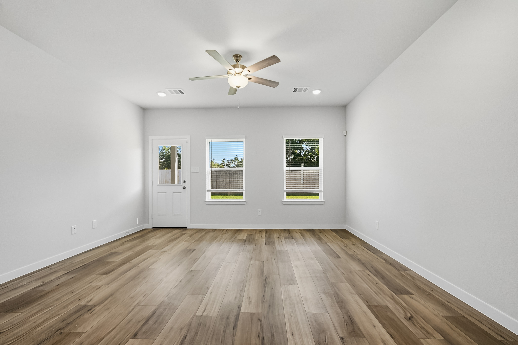 A room with a wood floor and a ceiling fan.