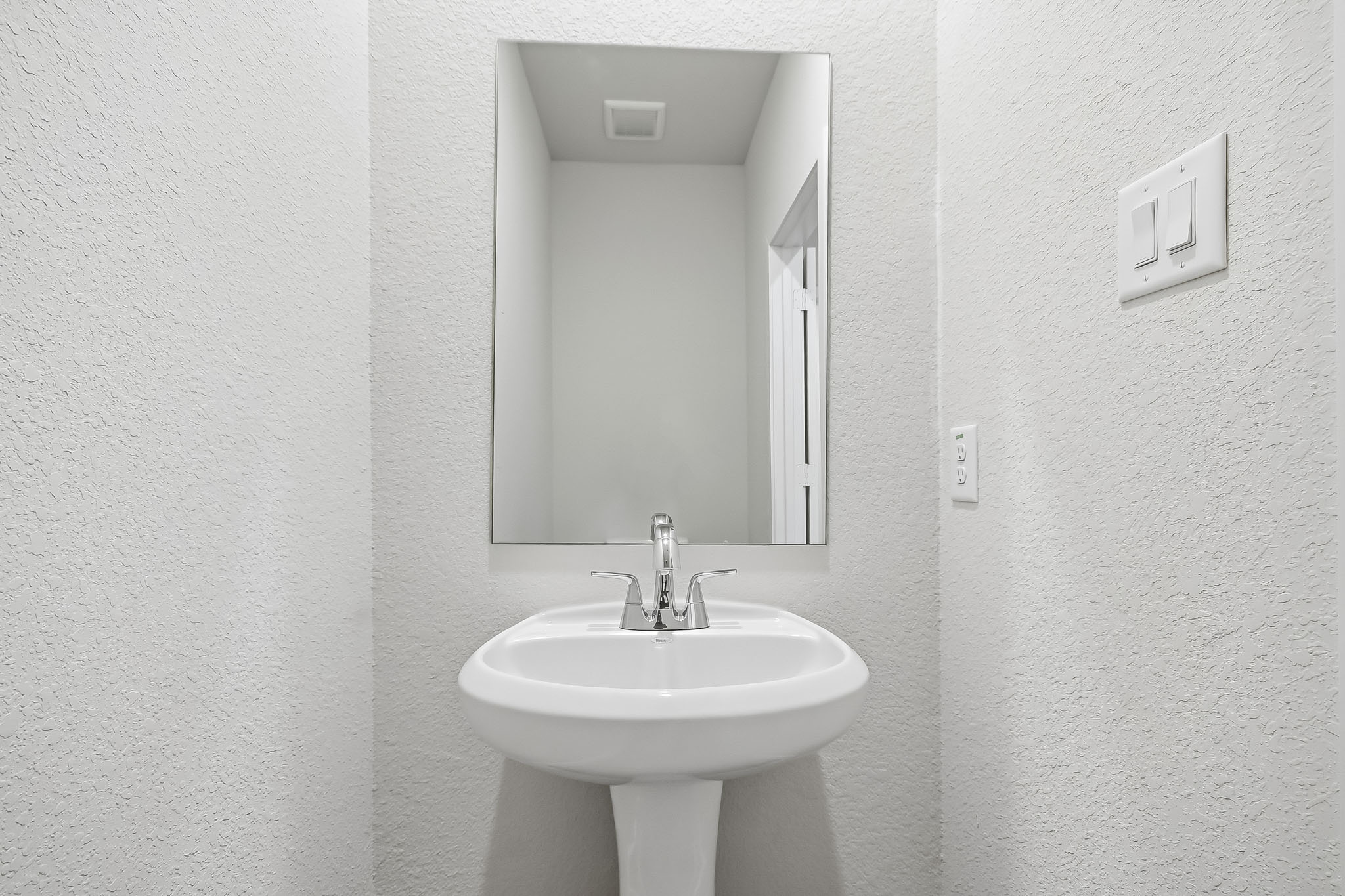 A bathroom with a mirror and sink.