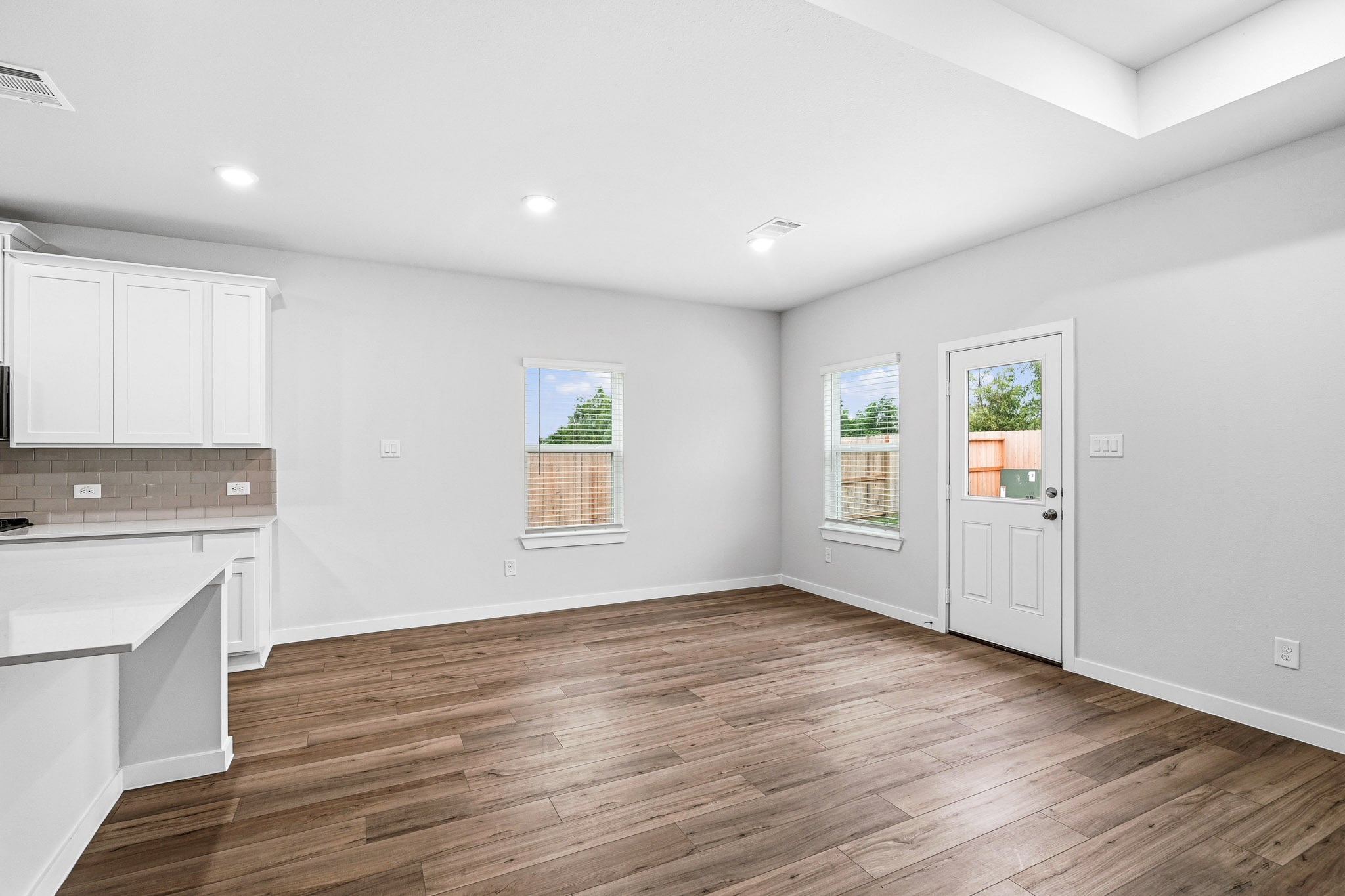A room with white walls and wood floors.