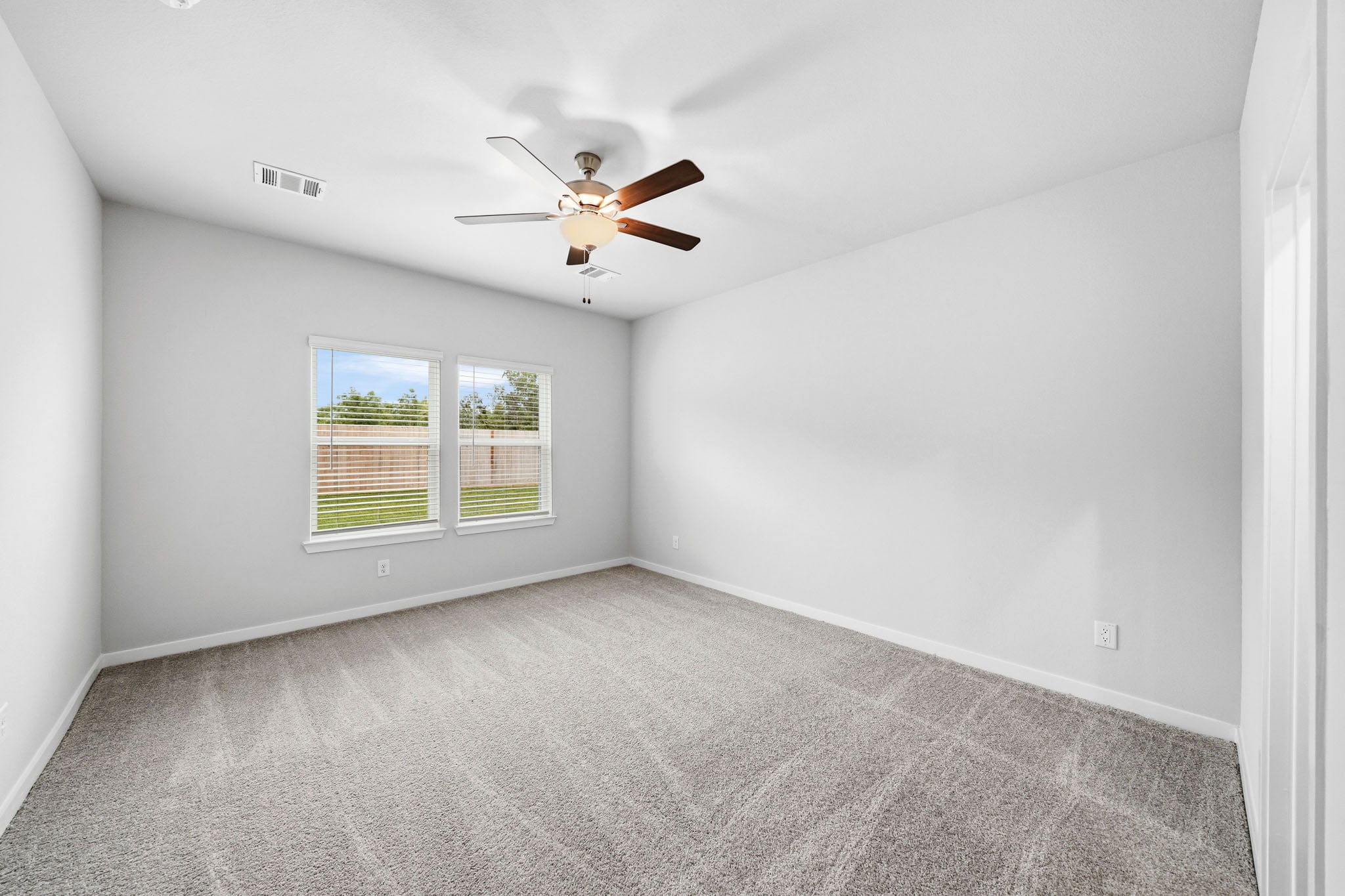 A room with a ceiling fan and a window.