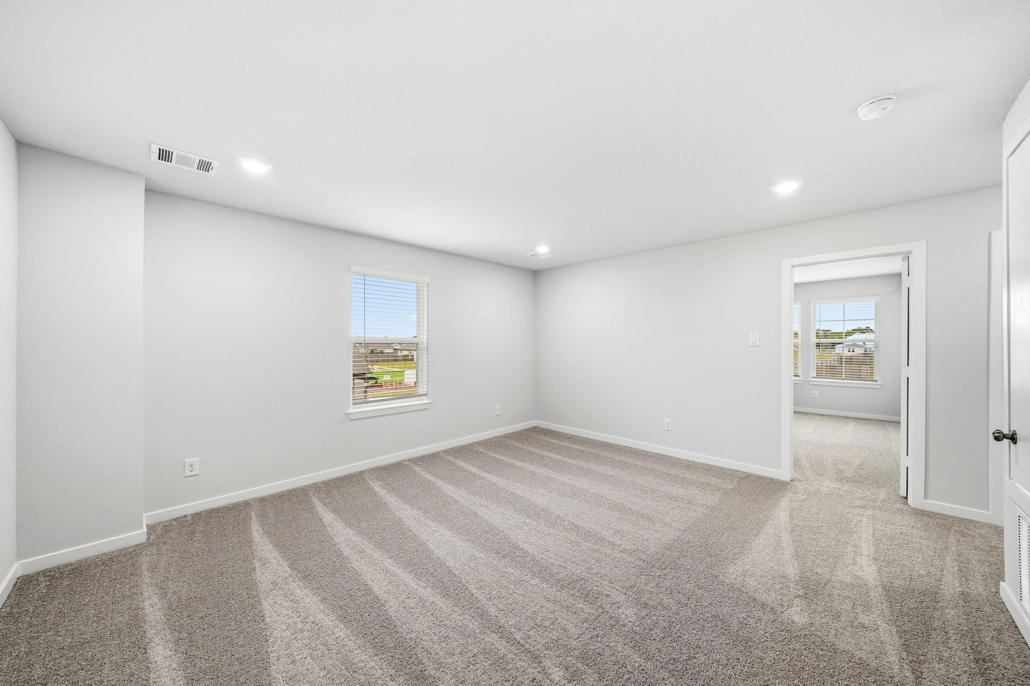 A room with a carpet and a window.