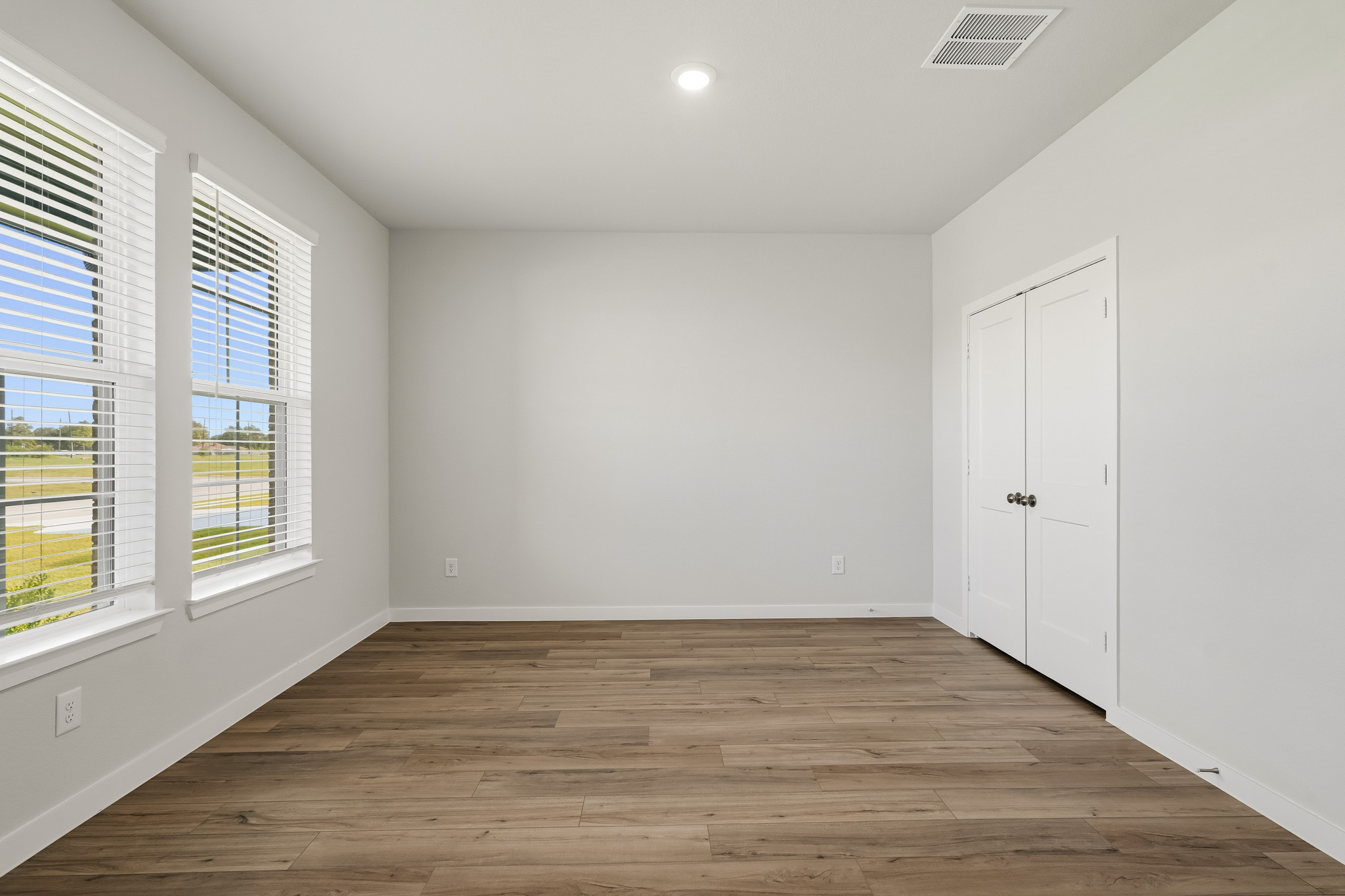 A room with windows and wood floors.