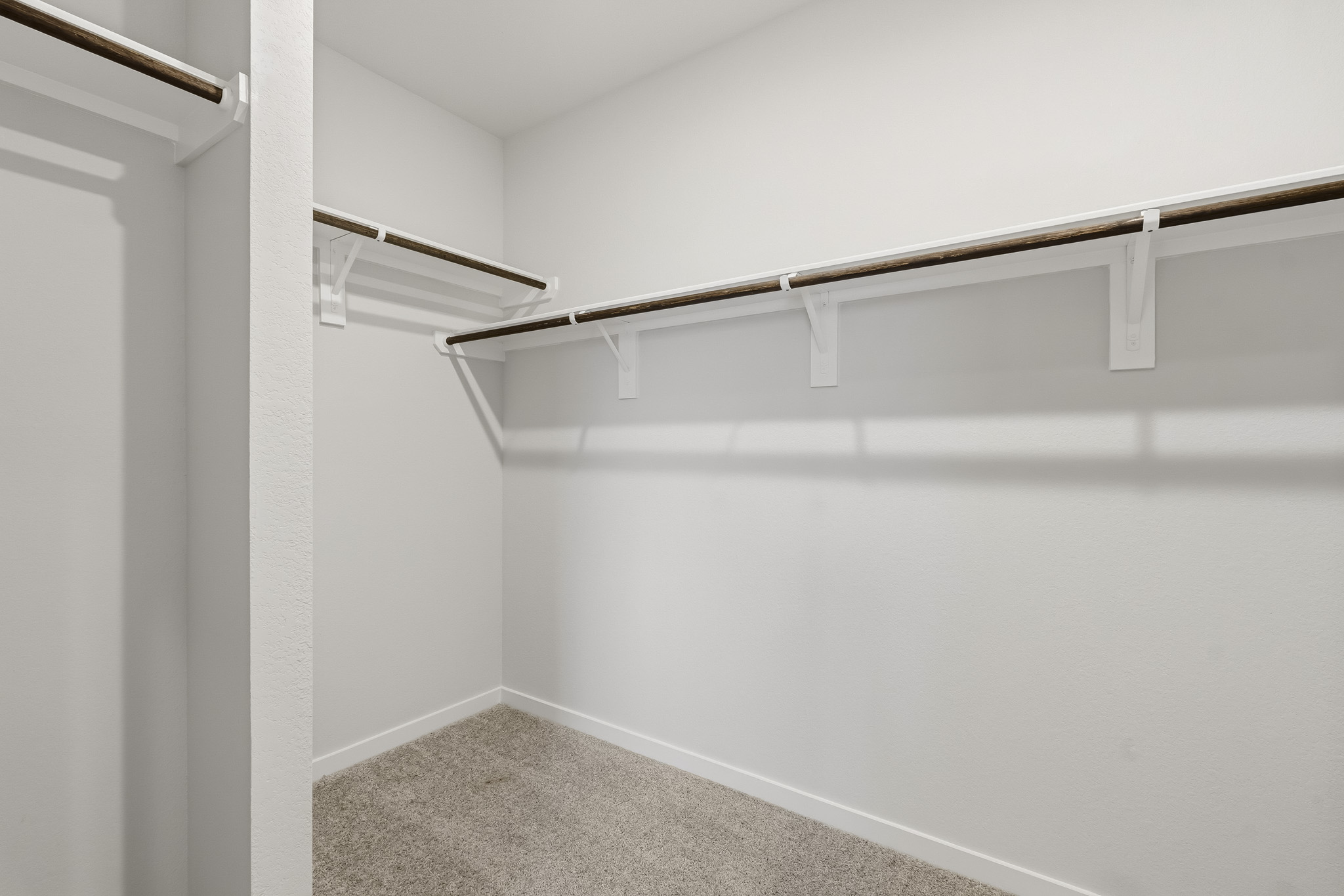 A white wall with a metal bar.