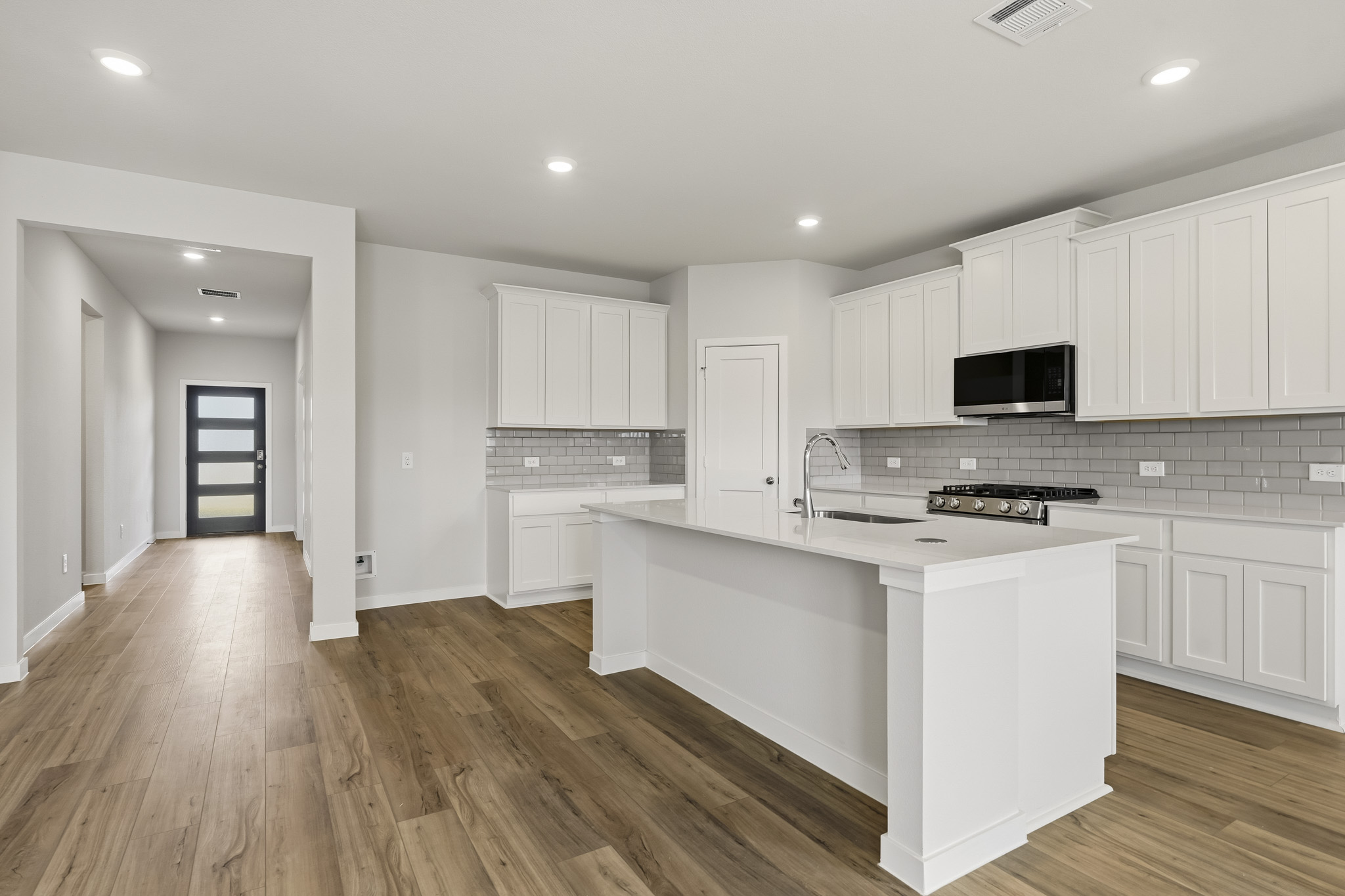 A kitchen with white cabinets.