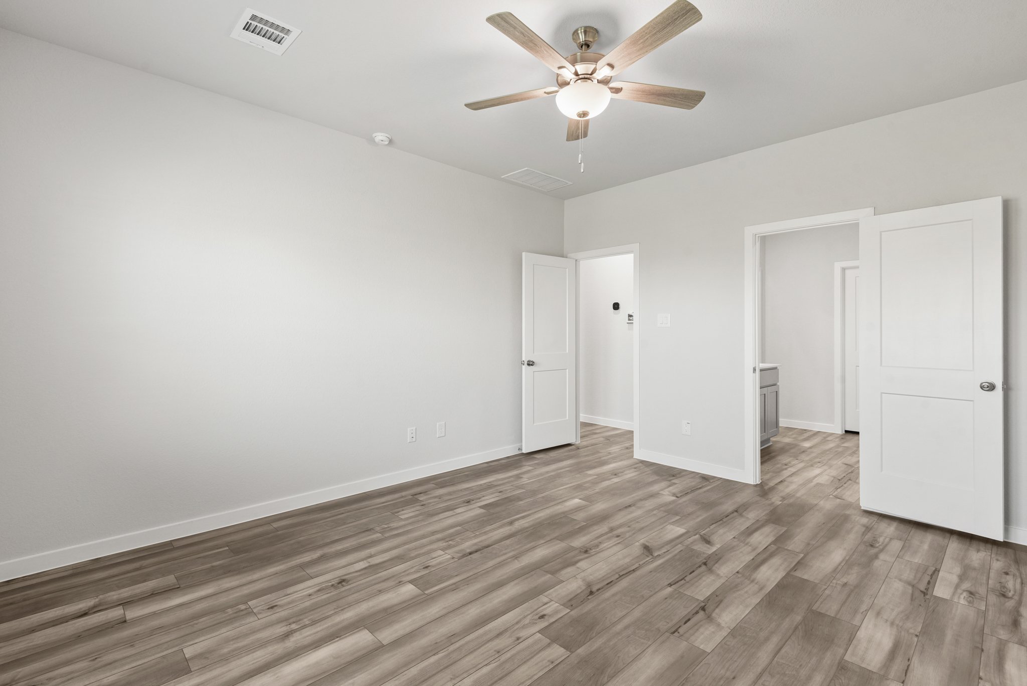 A room with a wood floor and a ceiling fan.