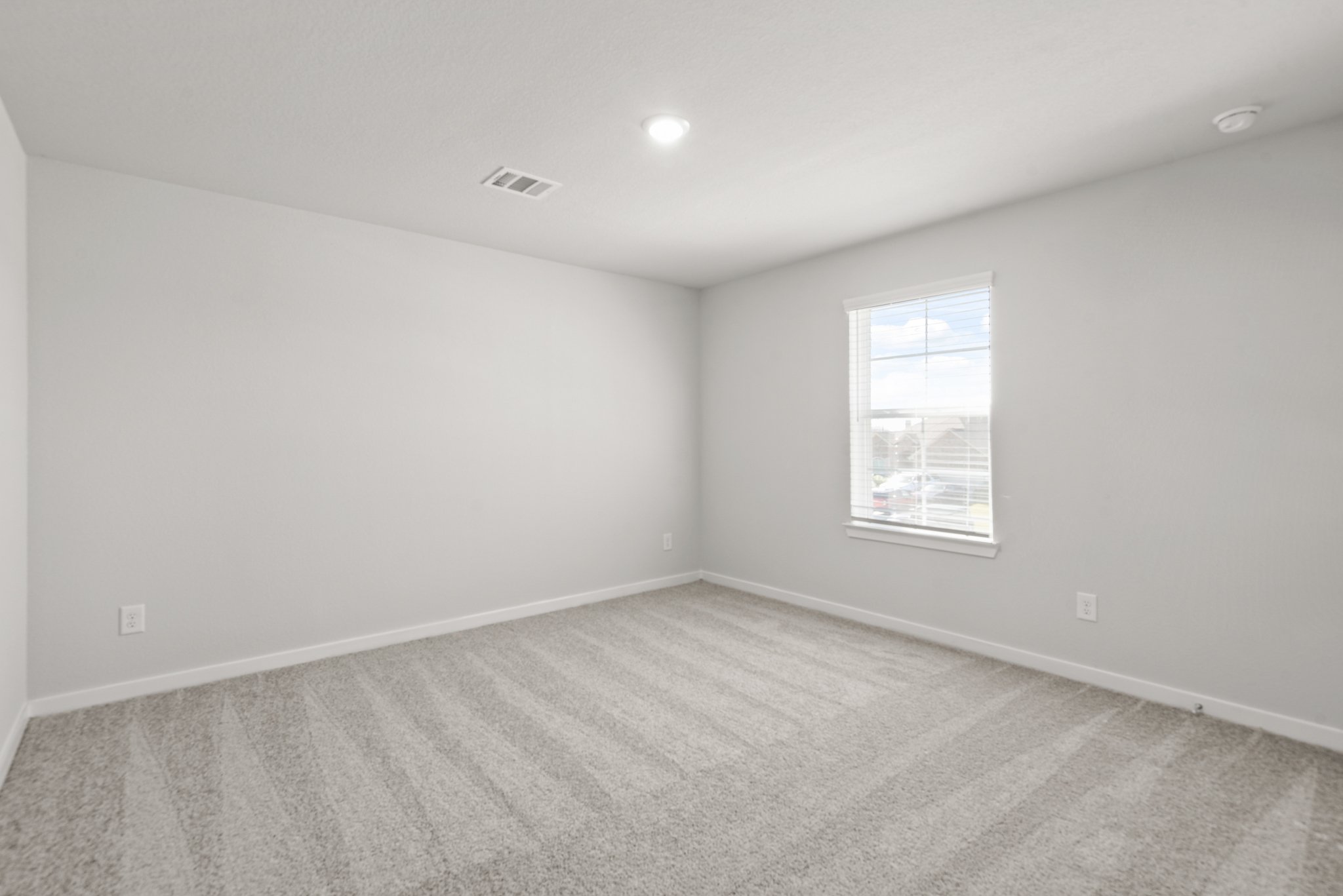 A room with a window and a carpet.