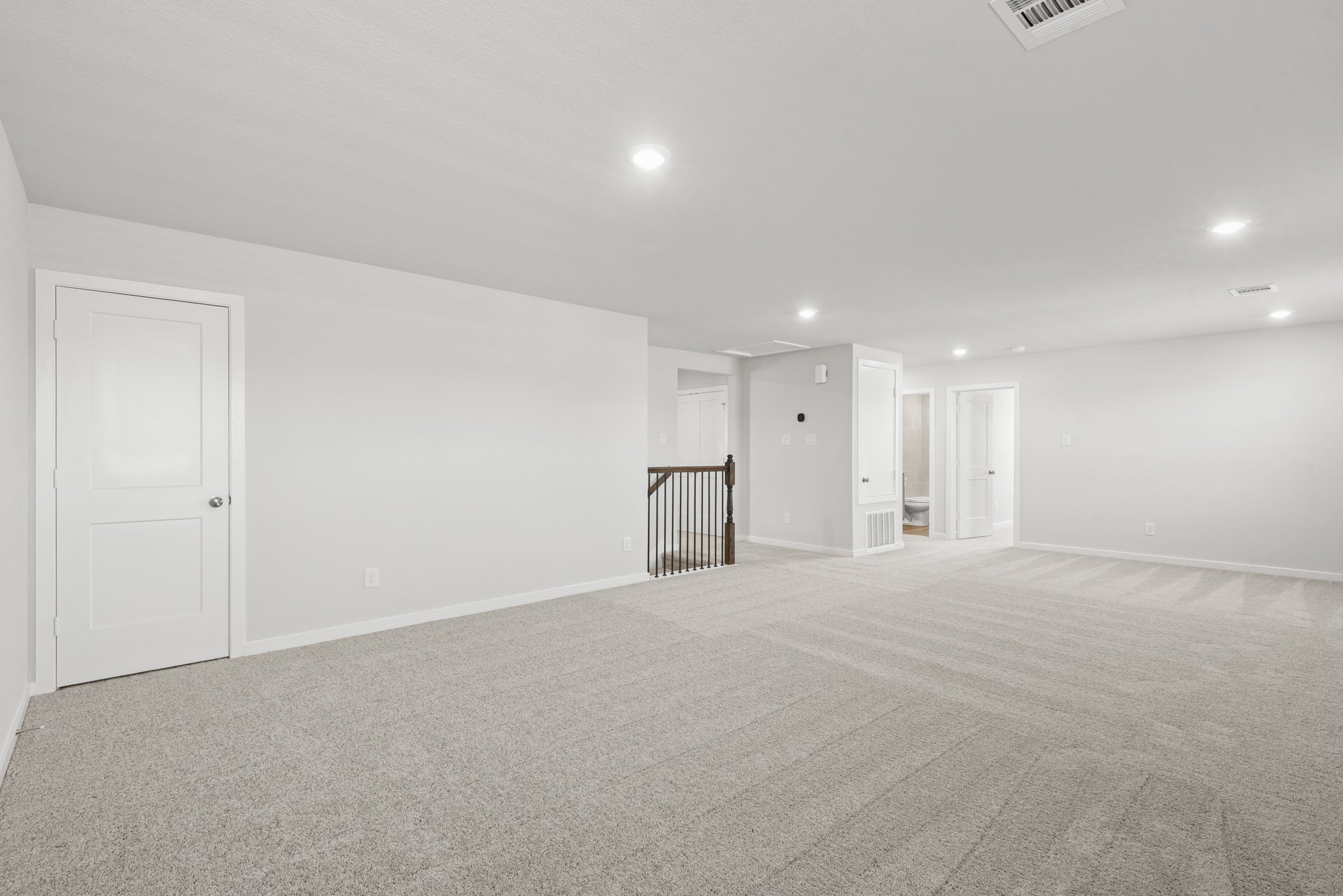 A large empty room with white doors.