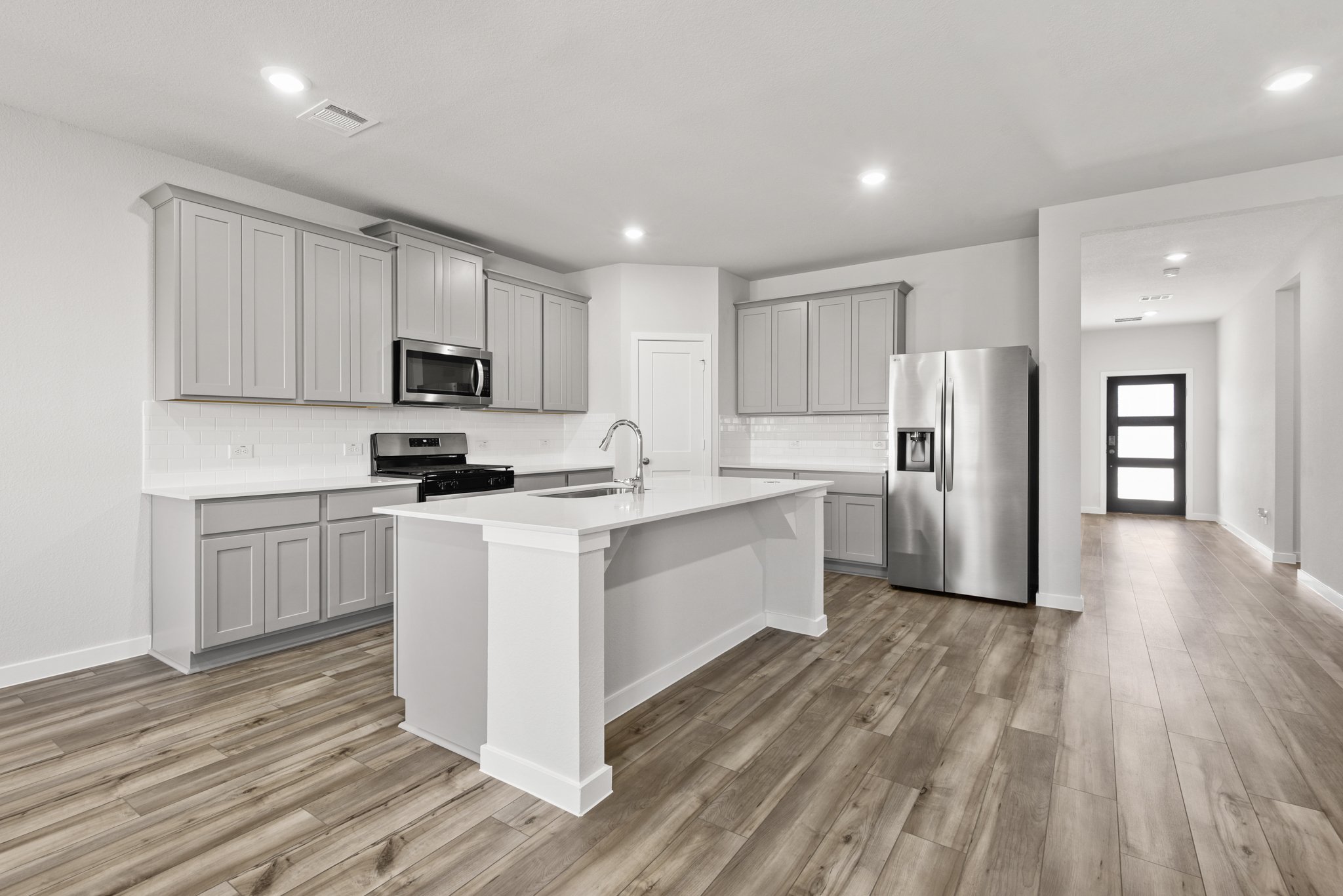 A kitchen with white cabinets.
