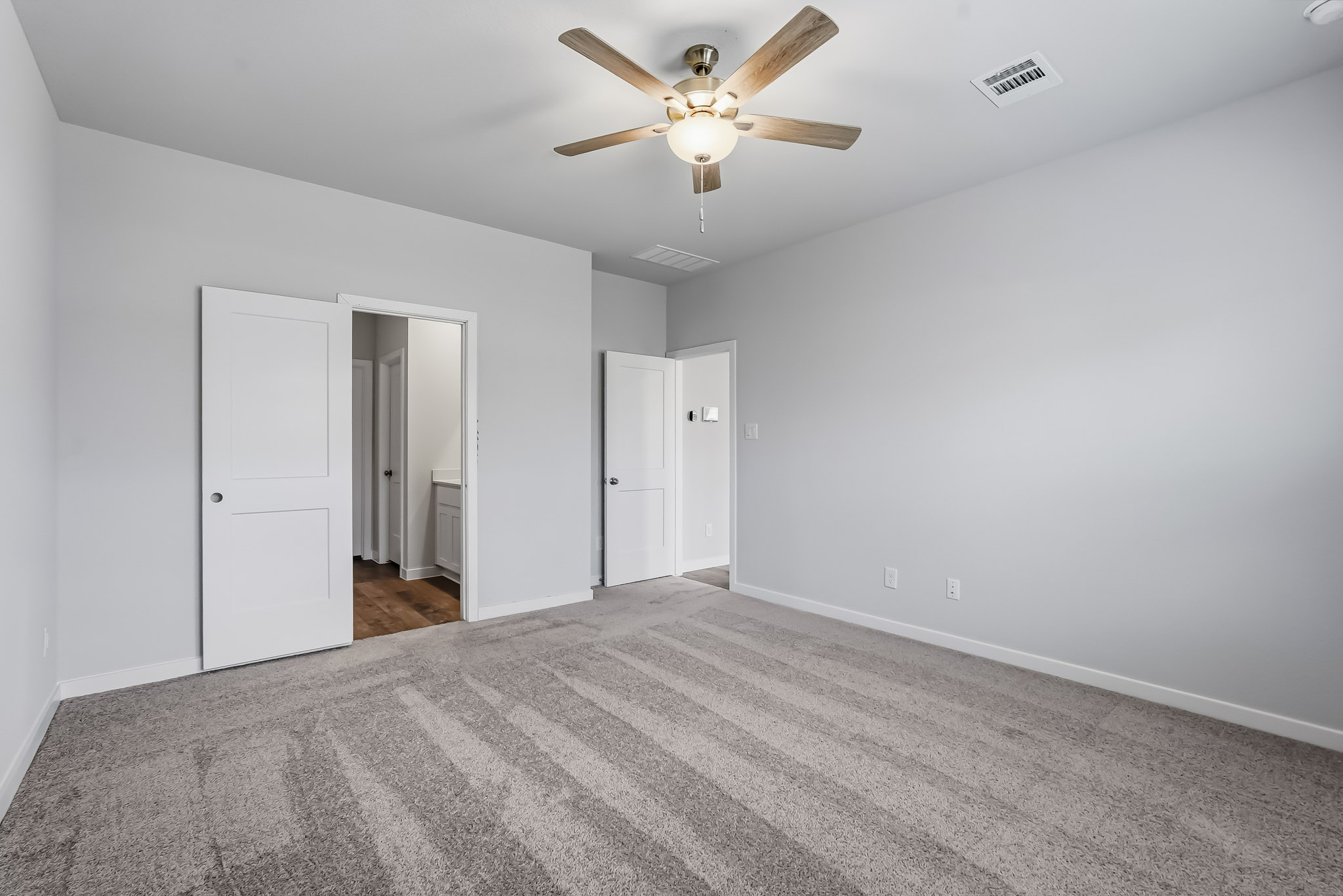 A room with white walls and a ceiling fan.
