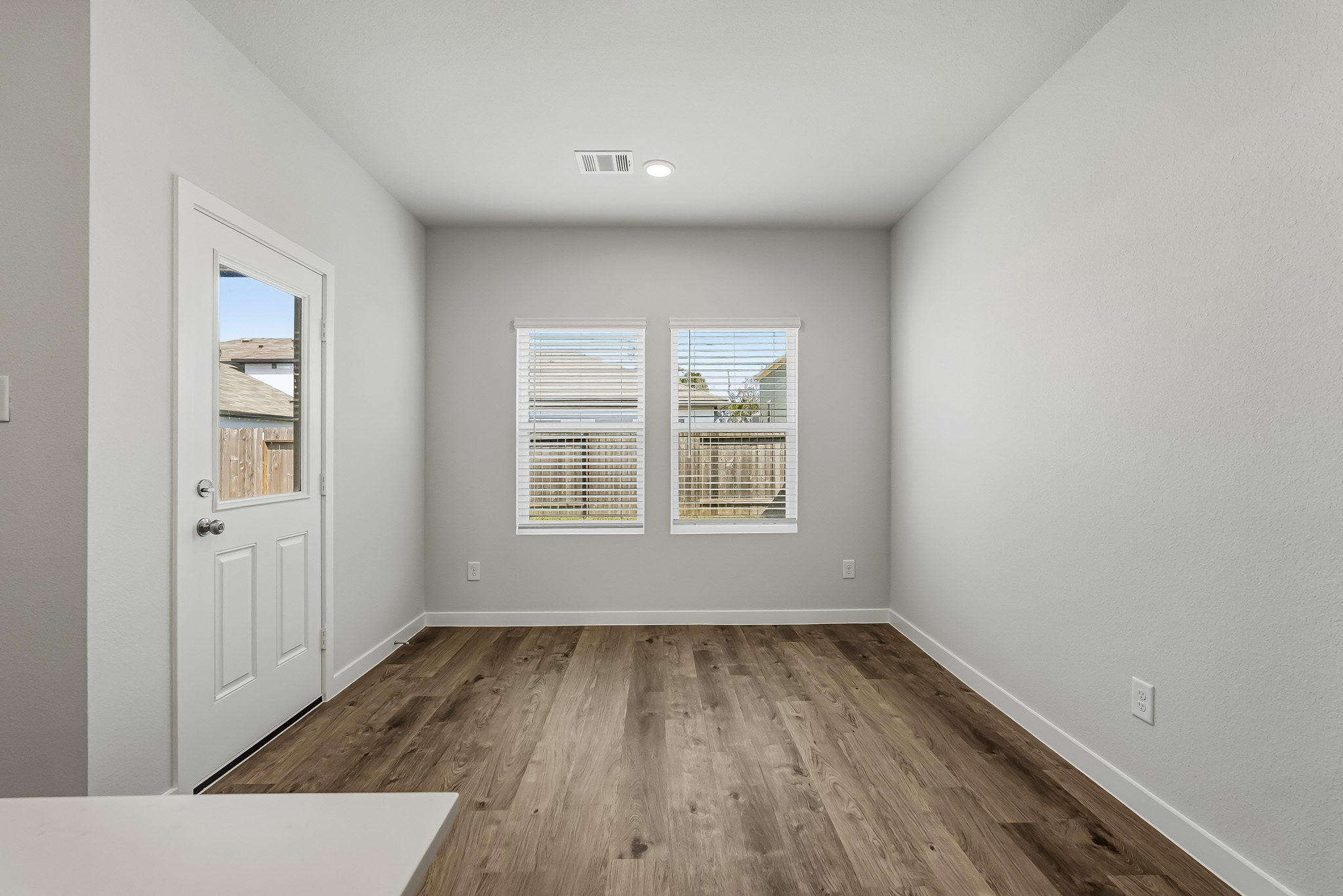 A room with a wood floor and a white door.