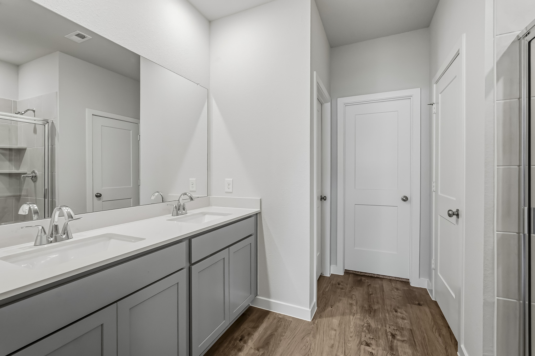 A bathroom with white cabinets.