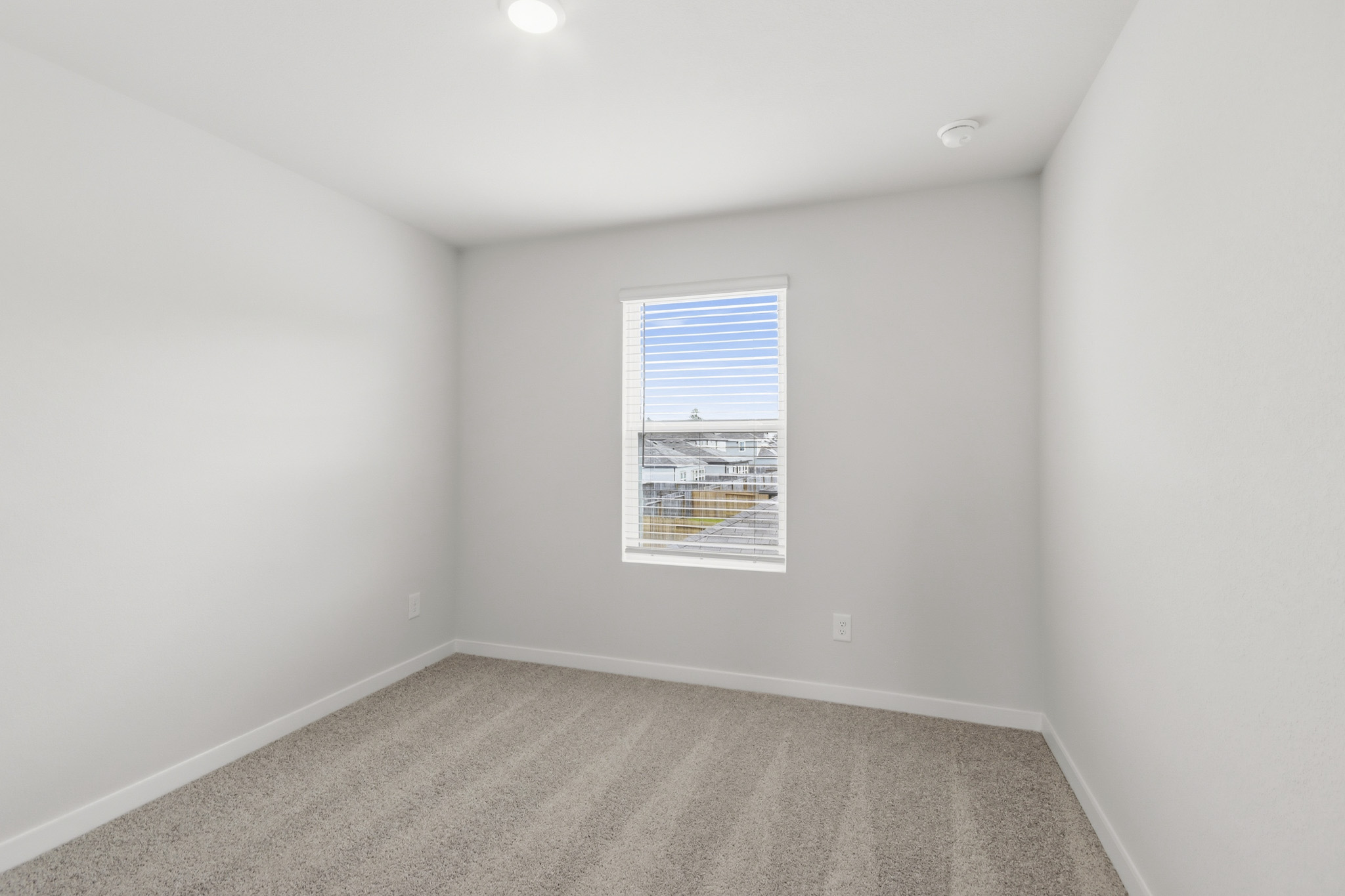A room with a window and a carpet.