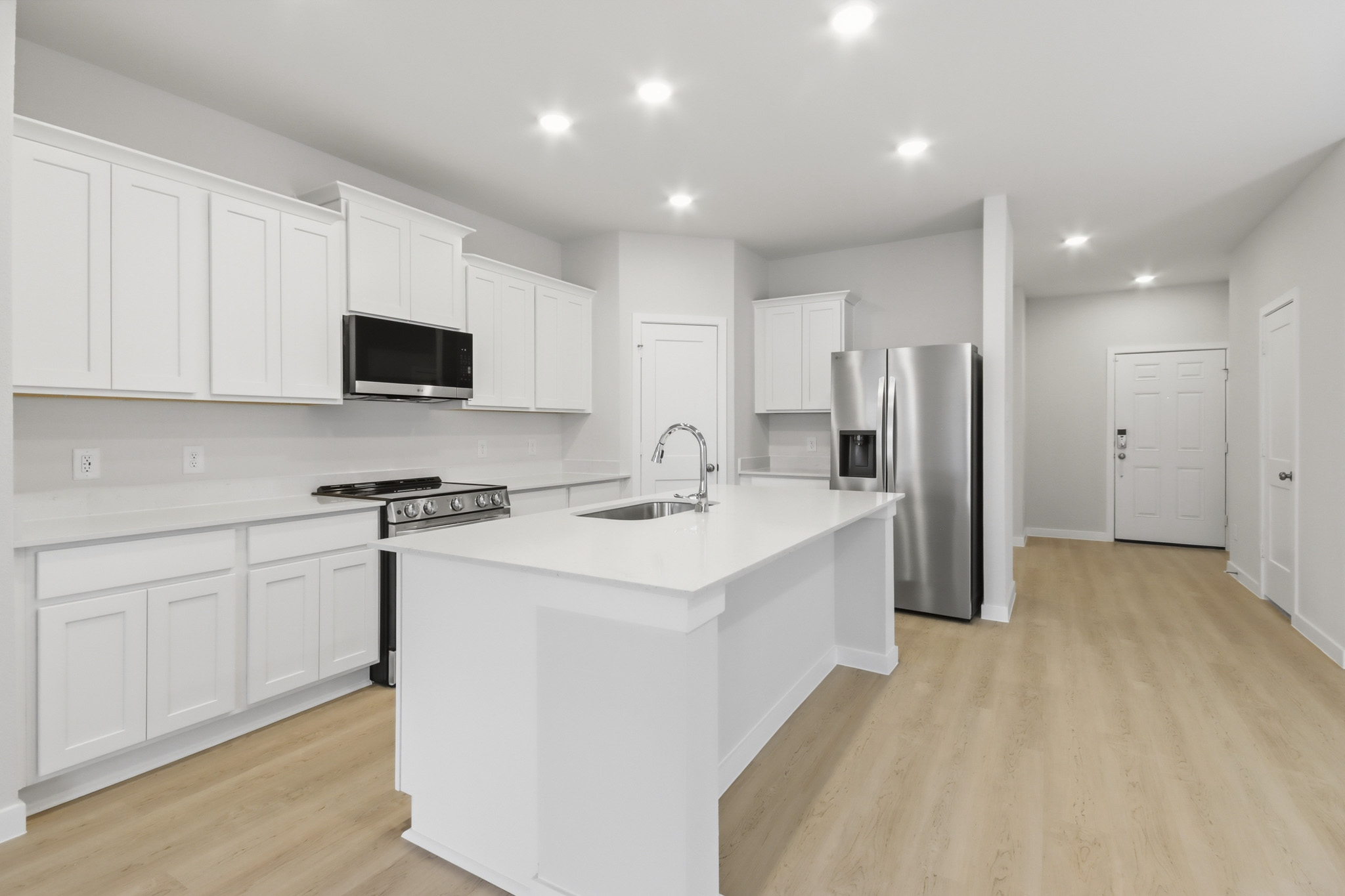 A kitchen with white cabinets.