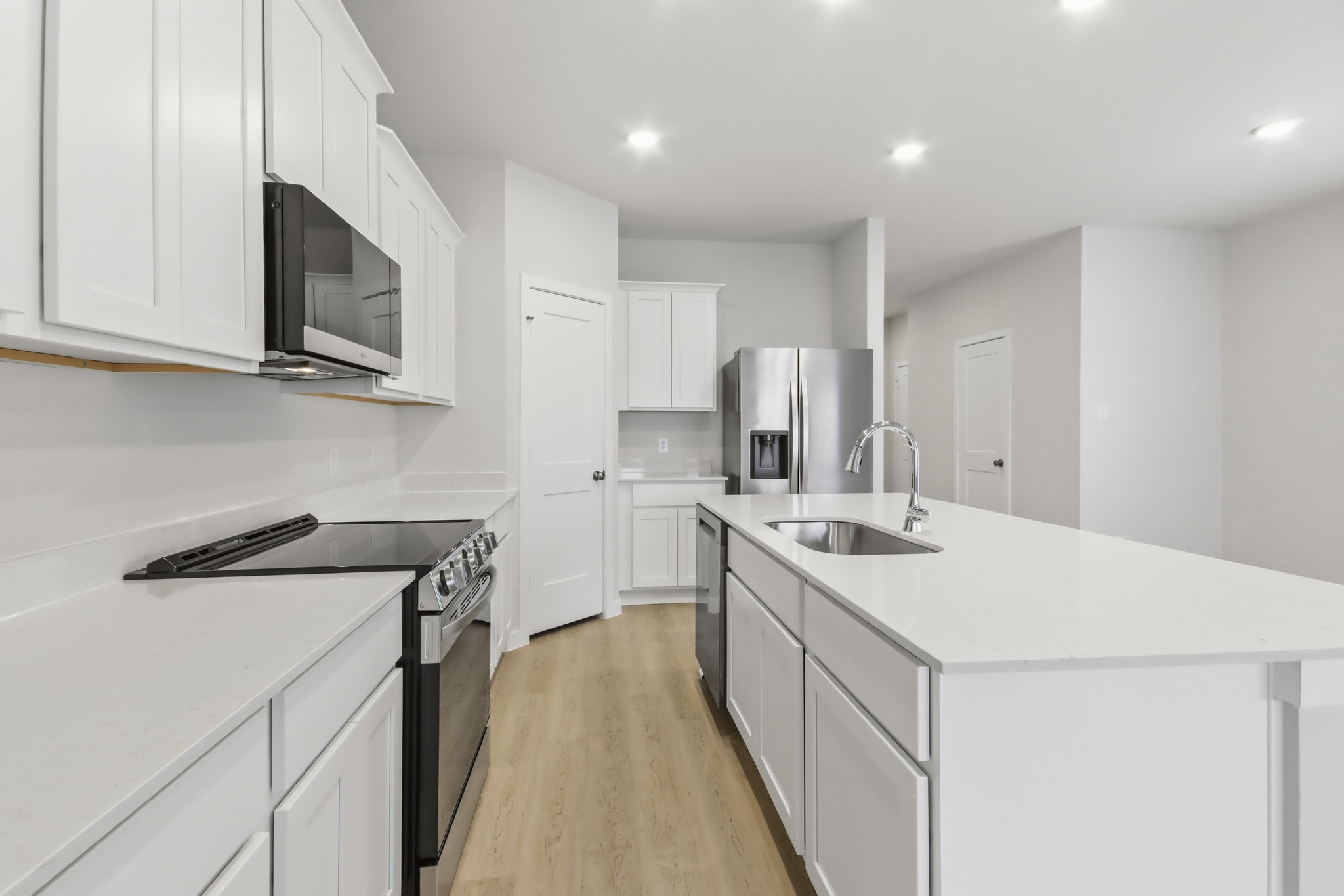 A kitchen with white cabinets.