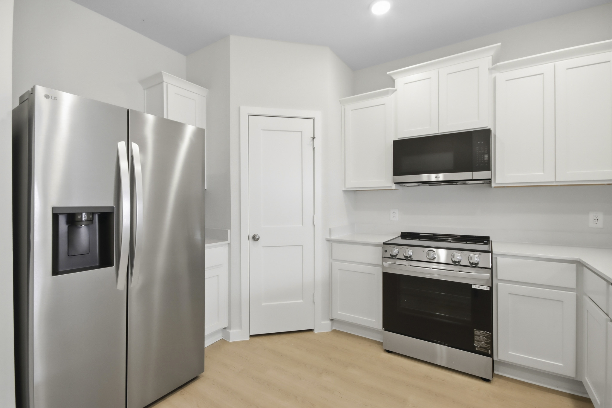 A kitchen with white cabinets.