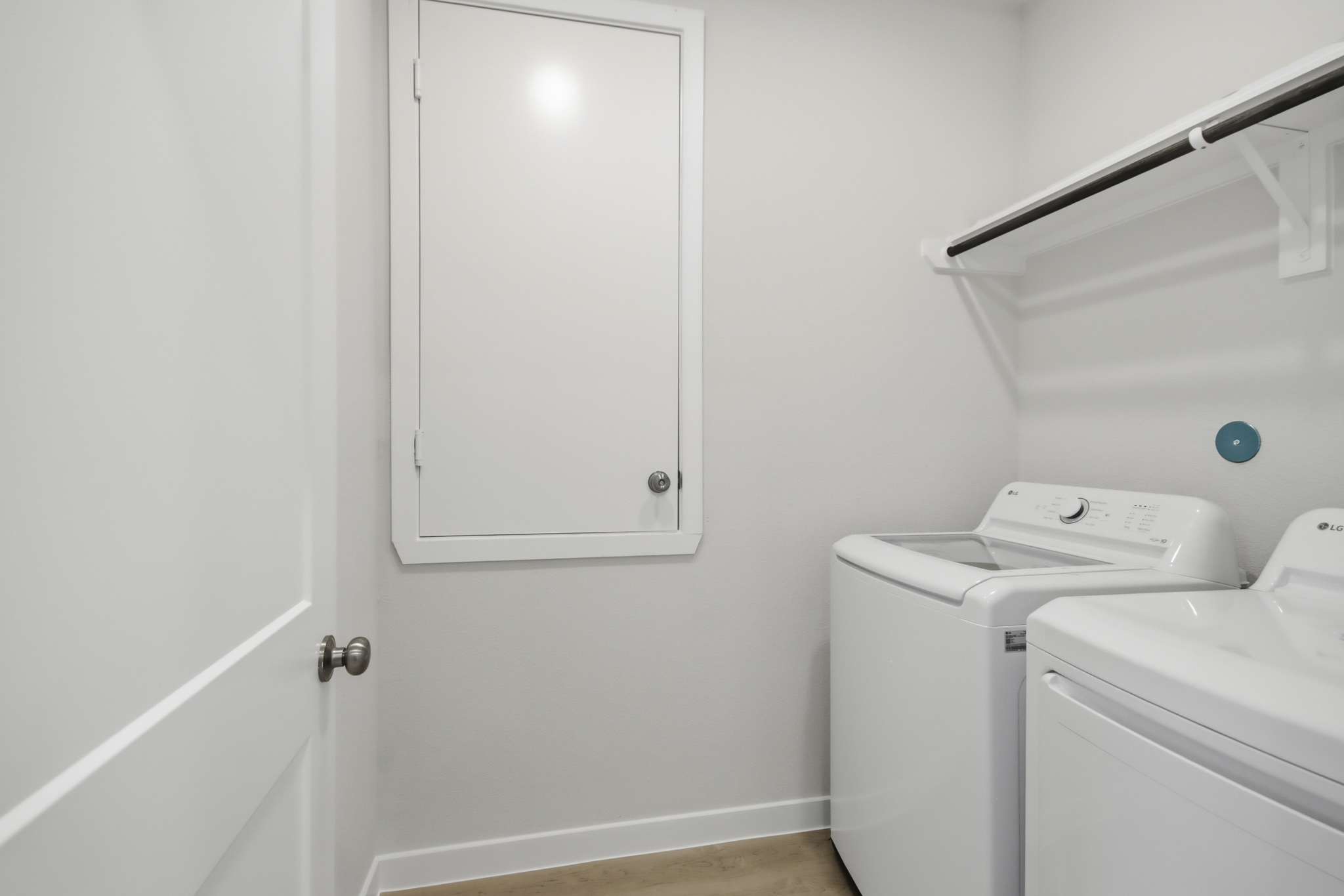 A white laundry room with a washer and dryer.