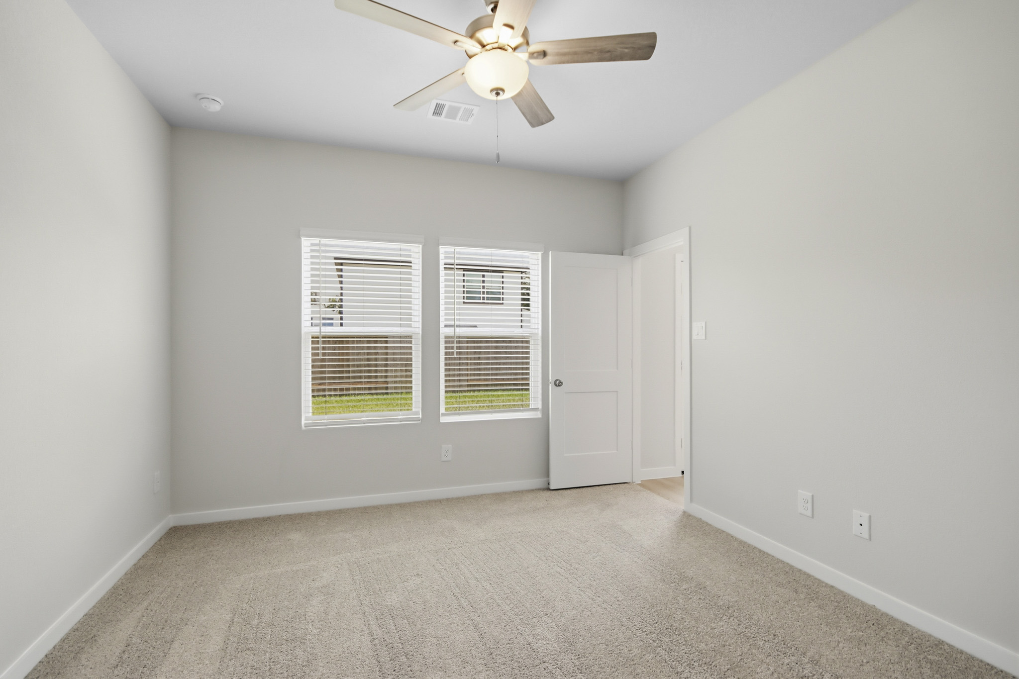 A room with a ceiling fan and a window.
